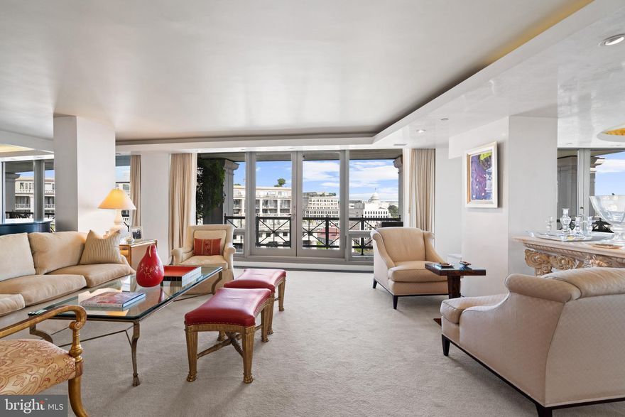 This exquisitely renovated offering, comprised of several combined units at The Residences at Market Square, has breathtaking views of the U.S. Capitol, the National Archives, and Pennsylvania Avenue. The spacious residence, located on an upper floor of this sought-after building with its beautiful neoclassical façade, is among the city’s most prestigious addresses. Bathed in dazzling natural light, the home offers sweeping, unobstructed vistas, generous rooms, and an open floor plan. Inside, Residence 1218 unveils a thoughtful interior—the result of a collaborative vision brought to life by Buch Construction, Hickok Cole Architects, and Peterman Designs. The floor plan has been elevated with premium upgrades, finishes, and materials. The entry begins with a striking wooden rotunda, accented with tray ceilings and recessed lighting, setting the tone for the sophisticated interiors. The expansive living room, wrapped in floor-to-ceiling windows, flows seamlessly into the dining room, where access to the wraparound terrace frames dramatic panoramic views. The gourmet kitchen is appointed with stainless steel appliances, custom cabinetry, and generous prep spaces. The primary suite is a serene retreat, featuring floor-to-ceiling windows, a spa-inspired bathroom with dual vanities, a frameless glass shower, and an oversized soaking tub. A custom walk-in closet with refined wood-paneled doors and extensive built-ins provides both function and luxury. The residence also offers a flexible second bedroom, study, or den with sliding wood doors for privacy, and an adjoining marble-accented full bathroom. Multiple storage closets and a powder room are also included. A dedicated bar and kitchenette elevate the home’s entertaining experience, with bespoke shelving, glass display storage, and marble countertops that open to the living spaces. Additional highlights include automated shades, curated shelving throughout, and a wraparound terrace—perfect for private enjoyment or hosting with the city’s most iconic backdrop. The Residences at Market Square offers an unparalleled suite of amenities, thoughtfully designed to complement a refined urban lifestyle. Residents enjoy the convenience of a 24-hour concierge, fitness center, and dedicated storage units, as well as an expansive rooftop terrace with a swimming pool, outdoor grilling area, and sweeping 360-degree views of the Washington Monument, U.S. Capitol, National Archives, and U.S. Navy Memorial. Ideally situated just steps from the Archives/Penn Quarter Metro station—and surrounded by Washington’s premier cultural institutions, fine dining, world-class shopping, and acclaimed theaters—this distinguished residence epitomizes sophisticated city living.