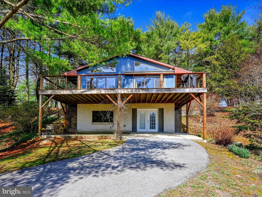 You will find this hidden, chalet style home, tucked away in the serenity of a rural setting, adorned with country views, a pond, woods and plenty of greenery.  A paved driveway leads you onto the property, and through the bottom doors into a bonus room, with storage space, for your needs.  There is a full bath, bedroom, laundry room and utility room for convenience.  Stay warm over the winter with your choice of electric, oil or propane fireplace heat! 3 mini splits are located throughout the home for heating and A/C.  Wander up the staircase to a cozy fireplace, in the living room, which hosts sliding glass doors to gaze though, to the outdoor scenery.  Take your pick for your favorite season and travel out onto the wrap around balcony/deck for your morning coffee, relaxation or taking in the wildlife! From the living room, you can travel into the kitchen and have your favorite meal prepared and consumed, again, with the outdoors in sight!  This level has another full bath, and 2 more bedrooms.  One bedroom allows an exit to a completely screened in porch where you can also access the wrap around front balcony/deck!  There is plenty of storage spaces throughout the home for your needs, and an access panel to attic storage as well.   This property does not stop there! A detached garage, for 1 car parking (if you choose), electrical panel, for tinkering, projects, hobbies- whatever you wish!  There is a pond added for beauty and recreation for fishing - catfish and coy!  An extra unit for storage is within the property boundaries. for your convenience of outdoor equipment.  Do yourself a favor - schedule a showing! You will not want to miss all this has to offer you!