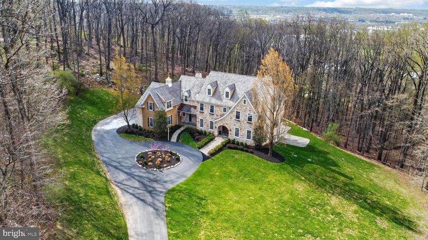 This stunning and sophisticated custom stone Colonial, set on a private 7.9-acre lot in Tredyffrin Township, showcases exquisite design and meticulous attention to detail throughout. A newly installed cedar shake roof enhances both the home’s durability and timeless curb appeal, while extensive exterior hardscaping further elevates the property’s exceptional outdoor living experience.  Inside, quality craftsmanship abounds with rich millwork, soaring 10-foot ceilings, site-finished cherry floors, expansive windows, and refined architectural details at every turn. The grand foyer welcomes you with a stately extra-wide staircase, flanked by a formal living room with coffered ceiling and elegant fireplace, and a richly appointed study featuring magnificent cherry millwork. The formal dining room, complete with glass French doors, opens to a well-appointed Butler’s pantry.  The gourmet chef’s kitchen is a true centerpiece, featuring Thermador stainless steel appliances, a large granite island, and beautifully crafted extra-tall cabinetry. Adjacent is the striking two-story, sun-drenched morning room with access to the slate patio. The family room impresses with a dramatic floor-to-ceiling stone fireplace and custom built-ins. Formal and informal powder rooms, a mudroom with secondary basement access, and a three-car garage complete the main level.  Upstairs, the luxurious primary suite offers a tray ceiling, private sitting area, and spa-like bath. Two bedrooms feature en-suite baths, while two additional bedrooms share a Jack-and-Jill bath. A spacious laundry room completes the second level. The walk-up third floor provides excellent storage or future living space potential.  The finished lower level is designed for entertaining, featuring a media area, custom wet bar with granite countertops, exercise room, powder room, expansive workroom, and walk-out access to a private covered patio.  Outdoor living is equally impressive, with a private patio complete with a cooking area and a beautiful stone fireplace—perfect for year-round enjoyment.  Located within a small, private community, this exceptional home offers convenient access to shopping, dining, corporate centers, Valley Forge National Historical Park, Paoli Hospital, and major commuting routes, all within the award-winning Tredyffrin-Easttown School District.  Additional pictures will be added next week but this is a must-see for the most discerning buyer.