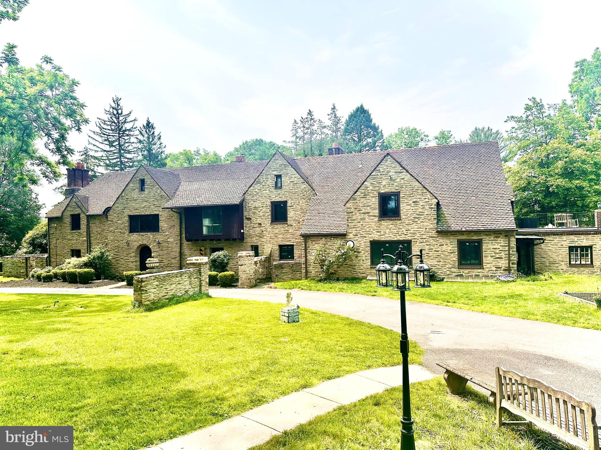 Set on 2.31 acres of private grounds, this 8,300+ sq ft stone estate offers a unique opportunity to own a
compound-like property Located in one of the Main Line’s most prestigious neighborhoods, this extra
ordinary home features three self-contained living spaces, providing unparalleled flexibility. The main residence exudes warmth and elegance, with 8 bedrooms and 4 full baths, making it ideal for a growing household. Classic hardwood floors, multiple fireplaces, and exquisite custom woodwork create an
inviting atmosphere throughout the home. The chef’s kitchen, with quartz countertops and a spacious prep area, serves as the heart of the home—perfect for both meals and entertaining. The formal dining room, adorned with rich wood paneling, provides an elegant setting for larger gatherings, while the cozy living room with its wood-burning fireplace is perfect for relaxation. The wood-paneled office offers a
quiet retreat for work or study, and the renovated bathrooms, including two with luxurious steam showers, provide both comfort and convenience. A true highlight of this estate is the expansive gallery space—a versatile space with vaulted ceilings, exposed beams, and a striking stone fireplace. This self-contained area includes its own kitchen, modern bath, laundry, and private entrance, offering limitless possibilities. Whether used as a home theater, playroom, art studio, event venue, or even a dedicated guest suite, this exceptional space can easily be adapted to suit your needs. Above the detached garage, the carriage house apartment provides another private living space with its own kitchen, living room, bedroom, and bathroom—perfect for extended household, guests, or as a rental unit, The estate’s 2.31 acres create the perfect setting for outdoor enjoyment. Relax by the heated saltwater pool, host summer gatherings on the stone terrace, or unwind in the glass-enclosed sunroom overlooking the serene backyard. With dual private entrances from Remington and Morris Roads, the property offers complete privacy, while still providing easy access to surrounding amenities. Ample parking ensures your guests are always accommodated, making this estate ideal for reunions, holidays, or any large gathering. This estate is an extraordinary place to call home.