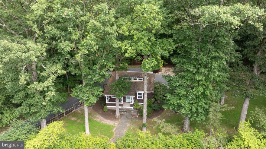 Nestled in a natural rural setting, this charming 1938 Arts and Crafts style bungalow offers a perfect blend of classic character and modern comfort. The park-like setting and Japanese-inspired cottage garden is tranquil and serene. The covered front porch welcomes you to step inside and discover a warm and inviting interior featuring solid hardwood floors, wainscoting, exposed beams and high ceilings. The bright living room is anchored by a wood-burning fireplace with hand-carved oak surround and mantel, perfect for gathering on chilly evenings, and flows nicely to the formal dining room with charming built-in corner cabinet. The country kitchen is efficient with built-in appliances, including a microwave and electric range, and substantial storage with period built-ins and traditional cabinetry. With three bedrooms and two full baths, including a primary bath with jetted tub, this home is designed for relaxation. Ample storage is provided by built-ins and large walk-in cedar closet, ensuring everything has its place. Outside, the expansive 0.84-acre lot features extensive hardscaping, a charming pond, gravel terrace and ipe deck, all surrounded by lush greenery and mature trees. Enjoy peaceful views of the garden and scenic vistas from the deck or patio, perfect for outdoor entertaining or quiet reflection. Located in a highly desirable area, this property offers the best of rural living while remaining close to local amenities. With a detached garage and carport, parking is a breeze. Experience the comfort and charm of this delightful home, where every detail invites you to relax and unwind.