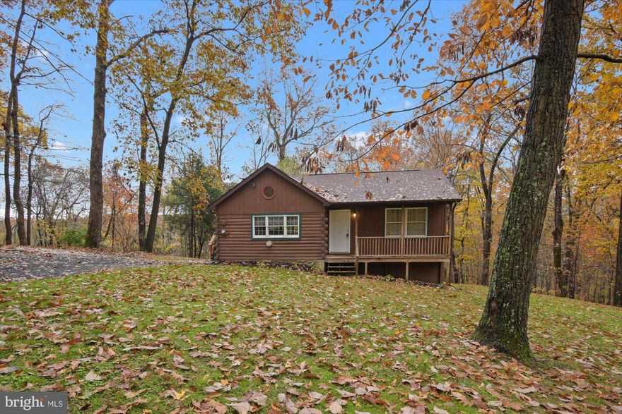 This secluded log cabin on 3.54 acres offers frontage on Deer Creek & recent improvements throughout: updated kitchen & bath, updated Andersen windows, updated plumbing & electric.  The bathroom has a custom built ceramic tile shower with double shower heads and glass doors.  Stacked stone fireplace with cozy wood stove is great for easy heating. Hardwood floors and vaulted ceilings in the kitchen and living room.  Property has waterfront access to Deer Creek that is great for recreation, fishing, etc.  Sit on the large covered front porch or the 15x24 rear deck that overlooks Deer Creek Hollow & appreciate the privacy & peacefulness.