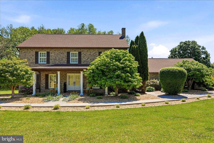 Nestled among the rolling countryside of Jefferson County and surrounded by beautiful estate homes and picturesque horse farms, this timeless custom-built brick estate offers an extraordinary opportunity to own 12.8 deeded acres of scenic West Virginia beauty with no HOA restrictions. Tucked away in one of the area’s most sought-after rural settings, the property blends privacy, elegance, and the peaceful rhythm of country living just minutes from Charles Town. 

Thoughtfully designed with character and craftsmanship throughout, the home showcases unique custom windows, abundant natural light, and interior plantation shutters that create the perfect adjustable ambiance from morning to evening. Spacious and inviting living areas were designed to embrace both comfort and entertaining, featuring a large open family room that flows beautifully alongside the formal living room, open dining area, and expansive kitchen spaces. The exceptionally large primary bedroom offers a peaceful private retreat, complete with two closets — including a walk-in closet — and a spacious en suite bath featuring dual vanities and a relaxing soaking tub.  The sun room serves as a peaceful retreat overlooking the surrounding landscape and offers seamless access to the rear deck, saltwater pool, and charming gazebo — creating an effortless indoor-outdoor lifestyle surrounded by nature’s beauty. The expansive deck features built-in bench seating and generous space for patio furniture, making it ideal for entertaining, quiet mornings, or relaxing evenings while taking in the peaceful setting.  The home is complemented by a newer 2019 roof and impressive 400-amp electrical service.

The grounds are truly exceptional! Lush landscaping and extensive hardscaping frame the home beautifully, creating a setting that blooms with color and character through every season. Open pasture, mature trees, and sweeping countryside views provide a serene backdrop for everyday living, while the private saltwater in-ground pool invites quiet relaxation and unforgettable gatherings alike. The 12.8 deeded acres allow for agricultural use and offer endless possibilities — ready for your animals, farming pursuits, or entrepreneurial vision. The property is currently taxed as and in farm use, with open fields maintained through a hay production agreement with a local farmer. New owners may continue this arrangement if desired, preserving the property’s pastoral charm and productive use or pursue their own agricultural interests.  

Whether envisioned as a full-time residence, refined country retreat, or equestrian-inspired escape, this remarkable property captures the romance of elegant rural living while remaining conveniently located to commuter routes, historic towns, and everyday amenities.