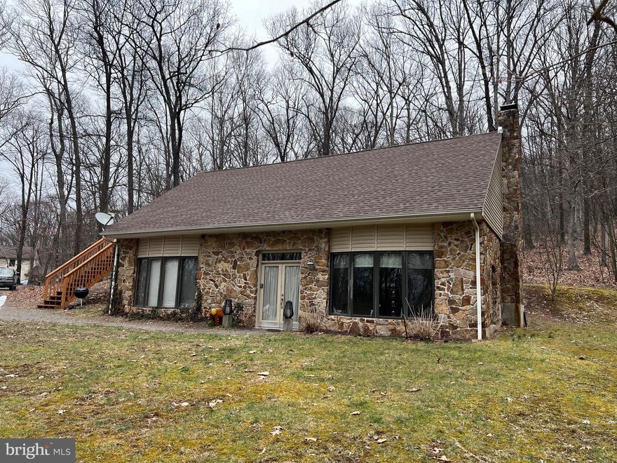 HIGHEST AND BEST OFFER DUE BY FEBRUARY 26th , 5:00 pm.   Adjoining 22,000 acre Sleepy Creek Public Forest - 5 wooded acres with this Berm home. Featuring: 2 BRs, 2 BAs, light filled Great Room with 9+ foot ceiling and beautiful stone wood burning fireplace.   Open concept with dining area and kitchen with stove, refrigerator, dishwasher.  Laundry closet with washer & dryer.    This property can be used as an Air B&B,  has Frontier internet and comes with most furnishings.