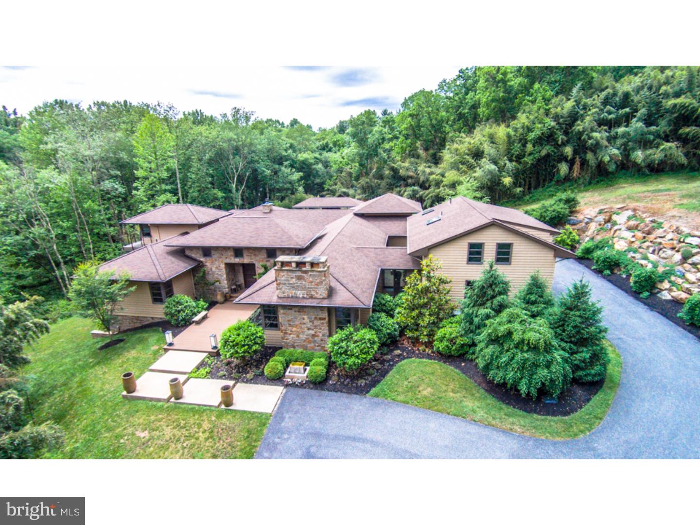 Welcome to Serenity. This 10,000 square foot private oasis is a designer dream home basking in warm, natural light, soaring ceilings & walls of windows nestled on an enchanting 4 acre parcel in the heart of Chadds Ford, within close proximity of upscale shopping & dining yet tucked amid the trees & bamboo of the Brandywine countryside. Oh and this home knows how to make an entrance! The dramatic entry foyer spills endless amounts of natural light into the home with a fifteen foot high glass wall overlooking the interior courtyard. The wow factor does not stop there-the majestic foyer also centers the eye on the pool & outdoor fireplace, allowing for an expansive field of view from the front door through to the stone Buddha atop the outdoor fireplace at the far end of the estate. The view is transcendent and unforgettable, bringing the amazing outdoor setting inside! Serenity is graced with many unique features including: 8 foot European doors, floating drywall, hand hewn lumber, copper accents and an awe inspiring array of design elements that must be seen to fully appreciate. The home harmoniously moves around the interior courtyard offering expansive entertaining spaces including a great room with slate & copper fireplace & vaulted ceilings, dining room with tray ceilings & seating for 14 & a living room with stone wood burning fireplace. The centrally located & thoughtfully designed gourmet kitchen boasts a commercial range, three dishwashers, two refrigerators, 4 microwaves, custom appliance cabinetry & two islands. The kitchen is surrounded with skylights that caress the granite countertops with sunlight & can be opened & closed with the touch of a button. Every workspace has been carefully planned & plotted to allow for a chefs space that is a true joy to use! Entertaining is a breeze with the separate butler pantry with flamed granite & two wine refrigerators. There are also two hidden walk-in closets at the entrance foyer designed to offer a coat check room & serving room when they are needed! The master suite rivals a world class vacation oasis & offers exquisite views of the countryside with corner built sliders to a custom deck overlooking the grounds. The palatial master bath is adorned with an amazing hand carved, granite soaking tub overlooking the serene grounds & a two person shower with granite tile reminiscent of a cedar shake bath in an Aspen ski lodge. This bath, as well as all the baths offer radiant heated floors.