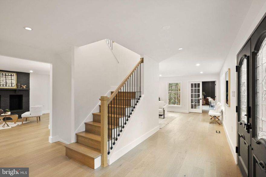 Wow—where do you start? This classic Great Falls estate has been completely reimagined and renovated with top‑of‑the‑line finishes and carefully curated design that fuses modern elegance with everyday function. Set on a serene, wooded 5‑acre lot, the nearly 7,000 sq ft of living space is move‑in ready and offers something for everyone. The main level showcases a gourmet chef’s kitchen with a 12' attached pantry, designer induction dual oven, striking hood, two dishwashers and a Cafe Series refrigerator—ample room to cook and entertain. The kitchen opens to a beautifully designed wet bar with custom Cafe beverage drawers and to a dramatic brick‑front hearth with wood‑burning fireplace that frames views of the private backyard. Seamless indoor‑outdoor living is perfected by the new main‑level deck, while the open living and dining rooms balance everyday comfort with the grace to host the most lavish affairs. The main‑level Great Room is an inspiring retreat, finished with custom moldings and abundant windows that flood the space with natural light. This exceptional property blends refined finishes, smart layout and peaceful acreage to create a rare Great Falls opportunity.