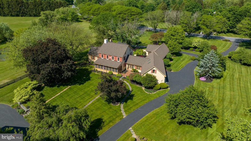 Spectacular eight-acre property on two parcels in the sought-after community of Stonehenge. Enjoy this secluded setting right in the heart of Manheim Township, yet you’re so close to local amenities, shopping, highways, airports, and more. The sprawling home originally built in 1852 with additions made in 1988 sits on six acres offering a tennis court, large barn, and a smaller stall barn. Horses are welcome! The barn area opens to a tranquil pasture with a pond and a meandering stream. The expansive grounds include lush landscaping, mature trees, a boxwood garden, a standalone fountain with a fish pond, and a decorative stone wall in the back of the home. Another two plus acre parcel sits on the other side of the pasture and stream. Moving to the main house, you’ll love the privacy of the primary suite area added to one side of the house with access to an exterior courtyard ideal for relaxing on warm sunny days. Besides the primary bedroom and attached bath, this addition to the original house includes an office, the laundry room, powder room, and bonus room upstairs that can be used for extra storage space. The primary suite area is connected to the main part of the house through a bright sunroom. Off the kitchen is a screened in porch that takes in the scenery of the yard and barn area. Two bedrooms and two full baths are hosted on the second level of the home. The main level features a living room and family room connected by a wet bar. The family room includes an eye-catching, large brick gas fireplace. Both the living room and family room have a wall of windows to enjoy the views of the surrounding landscape. A circular driveway and oversized three-car garage round out the grounds. The driveway also conveniently extends to the barns. With a spectacular setting, you won’t want to miss this peaceful, one-of-kind property. It’s a dream spot. Call today for a private tour.