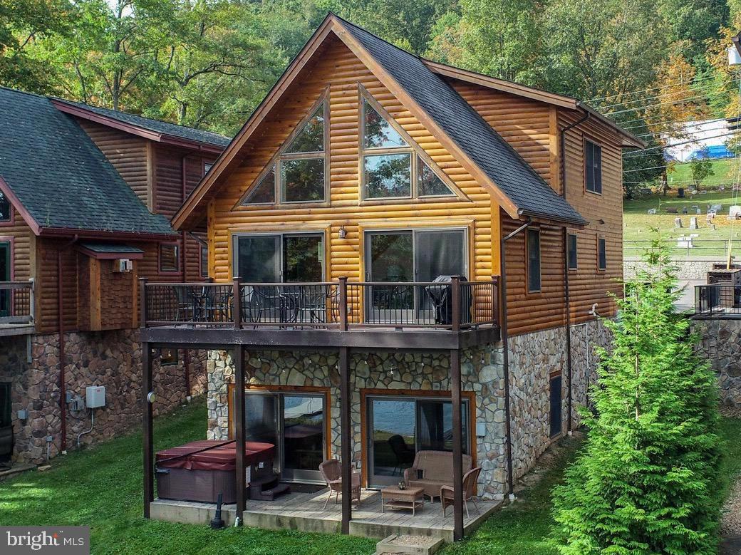 Stunning Lakefront Log Home at Deep Creek Lake!
Welcome to your dream retreat on Deep Creek Lake! This finely appointed 5-bedroom, 4.5-bathroom lakefront log vacation home was built in 2015 and offers the perfect blend of rustic charm and modern luxury. Boasting incredible lake views, a private Type A boat dock, and gently sloping lakefront, this property has everything you need for four-season enjoyment. Step inside to a spacious mud room entry—perfect for ski storage after a day on the slopes. The heart of the home features a gourmet kitchen with upgraded countertops, flowing seamlessly into a sun-filled open living room with vaulted ceilings, a stone fireplace, and expansive lake views. A primary suite with a tiled shower and double vanity offers comfort and privacy, while a composite lakeside deck provides the ideal setting for entertaining or relaxing with the water as your backdrop. Upstairs, you’ll find two additional primary suites, each with private baths, plus a loft overlooking the living room with breathtaking views of the lake and surrounding mountains. The walk-out lower level is designed for fun and relaxation, featuring a family room with lake views, a second stone fireplace, a pool table, and a wet bar with extra refrigerator and microwave. High ceilings enhance the open feel, while two more bedrooms and another full bath provide plenty of space for guests. Step outside to a covered porch with hot tub, perfectly positioned to enjoy year-round lake views. The gently sloping lakefront leads to an open, grassy area with just a few mature trees and a bordered fire pit for lakeside evenings under the stars. The property includes a private boat dock with deep water in a central location on the lake—ideal for boating, swimming, and fishing. Extra Features - Strong rental history with year-round appeal and location just a few minutes to Wisp ski resort, Mountain-inspired décor with rustic charm, Four-season destination for skiing, boating, hiking, and more. This home is a true gem at Deep Creek Lake—whether you’re looking for a luxurious personal getaway or a proven rental investment!