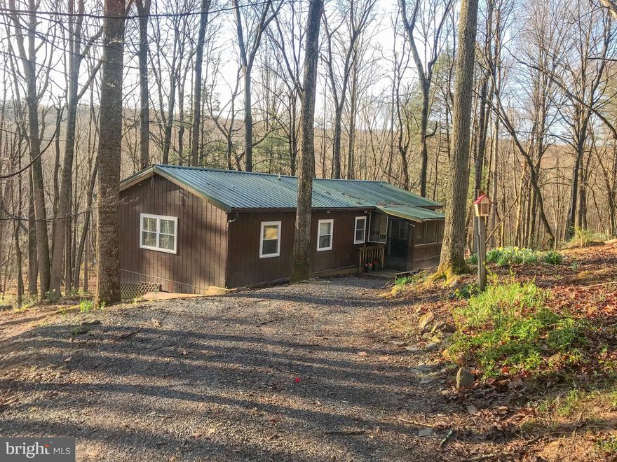 3BD/2BA CABIN ON 2.48AC with high-speed fiber optic internet. Renovated in 2018, and has had a successful AIRBNB in the past. Home comes tastefully furnished. Interior features include: Open Living/Kitchen Great Room, enclosed Sunroom for dining, Primary Bedroom with Ensuite Bath, Beamed ceilings in Great Room and Primary Room., new kitchen, baths and laundry. Exterior features include: new metal roof, new stone fire pit, screened porch, grilling deck, and garage/workshop. House includes generator for back-up power. Trout Pond Recreation Area with boating, fishing, swimming, camping, and hiking just minutes from your doorstep. Located less than 20 minutes from dining, shopping in Wardensville and Lost River. Less than 2 .5 hours from Washington, DC metro area. Make an appointment today!