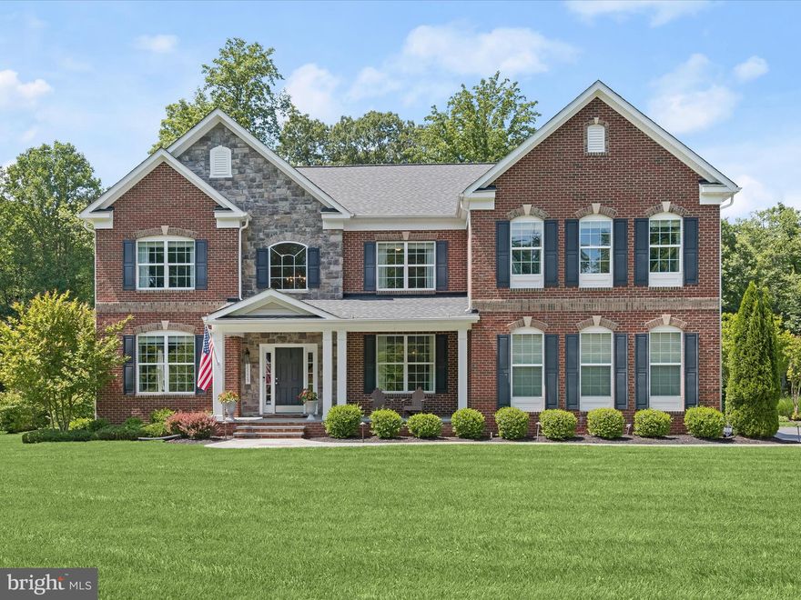 Welcome to your dream home in the serene and picturesque enclave of Woodbine! This gorgeous brick and stone accented colonial is impeccably situated on a tranquil, thoughtfully designed, and landscaped 1-acre lot, offering the perfect blend of rural charm and scenic beauty. Enjoy a quiet, country lifestyle while being conveniently accessible to Baltimore and Washington, D.C.  As you arrive, you'll be greeted by a luxuriously manicured lawn and a flagstone walkway leading to a welcoming covered front porch. The stunning stone and brickwork of the front exterior exudes timeless elegance.  Step inside the grand, 2-story foyer where polished elegance meets modern comfort. Exquisite millwork, rich wood flooring, and a neutral color palette set a sophisticated tone throughout the home. The formal dining room is an entertainer's dream, featuring a statement light fixture, box wainscoting, and ample space for festive gatherings. At the heart of the home, the gourmet eat-in kitchen boasts sleek stainless steel appliances, granite countertops, a double wall oven, gas cooktop, planning station, classic backsplash, and a center island illuminated by modern pendant lighting. Adjacent to the kitchen, the morning room offers a perfect spot for casual dining and opens to a custom-crafted deck, ideal for morning lattes or al fresco meals. The impressive family room features a lofty ceiling, floor-to-ceiling stone surround gas fireplace and Palladian windows that flood the space with natural light. A private office with French doors, a bonus room, powder room, updated entry room, access to the two-car garage, and a laundry room complete this exquisite main level. The upper level is an exciting collection of four bedrooms and three full baths. Retreat to the luxurious primary bedroom suite with an elegant pillared sitting room, cathedral ceiling, gas fireplace surrounded by built-in shelving, and plush carpeting. The impressive walk-in closet with a custom organization system makes it easy to find your favorite outfits and shoes. The en suite bath epitomizes luxury with a soaking tub, double vanities, water closet, and frameless glass surround shower with double showerheads. Each bedroom has its unique charm with focal point accent walls, ceiling fans, and attached baths for ultimate privacy. The sprawling lower level offers endless opportunities for hobbies, recreation, and exercise. The bar, with display cabinetry and granite countertops, is perfect for entertaining, while the game room is ready for friendly competitions of pool or foosball. The fifth bedroom, full bath, and two storage rooms complete this fun and flexible level. Your outdoor oasis features a custom patio and firepit area backing to the trees of a conservation area, providing tranquility and privacy. The storage shed blends beautifully with its surroundings, making lawn and garden equipment easily accessible. Recent updates to this luxurious home include a new refrigerator (2024), water heater and flagstone walkway (2023), upper-level bedroom trim work (2022), dishwasher (2021), laundry room remodel (2020), and newer hardwood flooring throughout. Don’t miss the chance to call this breathtaking home yours. Schedule a tour today and experience the perfect blend of luxury and tranquility in Woodbine.