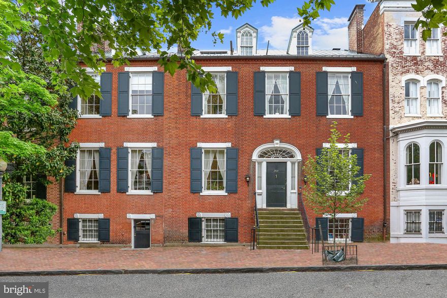 The Decatur House, located at 2812 N Street, NW, is extraordinary - even by the standards of the East Village of Georgetown which is filled with wonderful Federal mansions. This stunning and authentic 1779 brick residence still retains the glorious grounds that surrounded it when it was first built. In addition to visual magnificence it has a storied history which links the house to the national and colonial record of the United States. The house was the home of Susan Decatur who took refuge there after her husband, a Revolutionary War naval hero and Commodore of the Navy, was killed in a duel. Here, she entertained the dignitaries and the celebrities of the young America. 

The house is filled with history and maintains much of its original floor plan and details, a rare trait. The house was completely renovated at the beginning of the current owner's tenure and has been faithfully maintained since then by the District's most skilled contractors and tradesmen.  The facade is a perfect example of Federal architecture. The entire entry level has 12.5' ceilings. In proportion to this volume of space are the oversized windows and large fireplaces. The great drawing room is 34' long and flanked by two fireplaces and four sets of French doors which lead out to the covered porch. Beyond the great drawing room is the dining room which matches the grandeur and elegance of the previous space at almost 30' long. 
There are three bedrooms including the primary bedroom and three full baths on the second floor. The entire floor has ceilings over 11', and two of the bedrooms have French doors opening to the south balcony. 
The top floor of the house has two charming bedrooms of equal size. Each has two sets of south-facing dormers, its own full bath, and good closets and built-ins. There are two walk-in cedar closets at the end of the hallway, one with an original dormer window inside. The property also has off street parking for two cars.