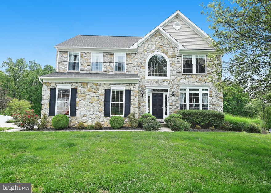 This stunning 4BR stone colonial is situated on a 1/2 acre lot that backs to a wooded natural protection area.  Enter into the 2 story grand foyer flooded with natural light to the open living/dining room with hardwood flooring.  The gourmet kitchen features stainless steel appliances, gas oven/stove, island, and granite counter-tops.  The kitchen opens to a sun-room with panoramic views of the wooded rear and access to the rear deck.  The master bedroom's vaulted ceilings, double doors, and built-in shelving create a bright and open feeling that promotes rest and relaxation.  The unfinished basement on the lower level provides ample storage space and walks-out to the rear yard and concrete rear patio.