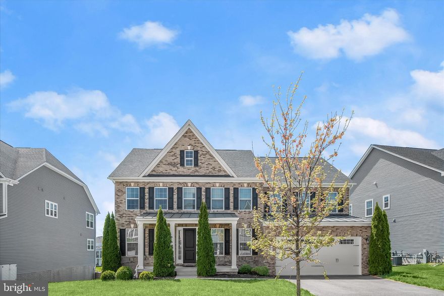 Welcome to 11047 Martha Way, an exceptional NV Homes Mary Mount model ideally positioned in the highly sought-after Maple Lawn South community. Built in 2018 and offering over 5,000 finished square feet, this elegant transitional residence seamlessly blends sophisticated design with modern comfort and functionality.  Step inside to discover hardwood flooring throughout the main level, enhanced by upgraded designer lighting and thoughtfully curated finishes. A private main-level study provides the perfect work-from-home space, while the mudroom with custom drop station adds everyday convenience. The heart of the home is the gourmet kitchen, featuring upgraded cabinetry, stainless steel appliances, a walk-in pantry, and an expansive entertainer’s center island with pendant lighting. A butler’s pantry/coffee bar connects effortlessly services main level spaces, while the sunlit breakfast room opens to a screened porch—ideal for indoor-outdoor living.  The adjoining family room is both inviting and refined, complete with a gas fireplace and direct access to the deck, creating the perfect setting for entertaining or relaxing. Upstairs, all bedrooms are ensuite, including a luxurious primary suite with tray ceiling, dual walk-in closets, and a spa-inspired bath with soaking tub, dual vanities, walk-in shower, and linen storage. A convenient bedroom-level laundry room enhances daily ease.
The fully finished walk-out lower level is an entertainer’s dream, featuring full daylight windows, a wet bar with back bar, and a spacious recreation area. A fifth ensuite bedroom and full bath offer ideal accommodation for an au pair, guests, or multi-generational living. Outdoor living is equally impressive with a brick front elevation, charming entry portico with standing seam metal roof, screened porch with sunshades, and a low-maintenance composite deck with vinyl rails. The walk-out leads to an expansive, tiered stone patio, all within a fenced rear yard complemented by front and rear lawns—perfect for gatherings or quiet enjoyment.
Located in the vibrant Maple Lawn community, residents enjoy an unparalleled lifestyle with resort-style amenities including a swimming pool, fitness center, tennis, basketball and pickleball courts, athletic fields, playgrounds, dog park, and miles of scenic walking and jogging trails. The community center offers event spaces, meeting rooms, and a variety of social programming throughout the year. Maple Lawn’s walkable town center features restaurants, cafés, shops, and everyday conveniences, creating a true live-work-play environment.  This is a rare opportunity to own a turnkey luxury home in one of Howard County’s most desirable communities.