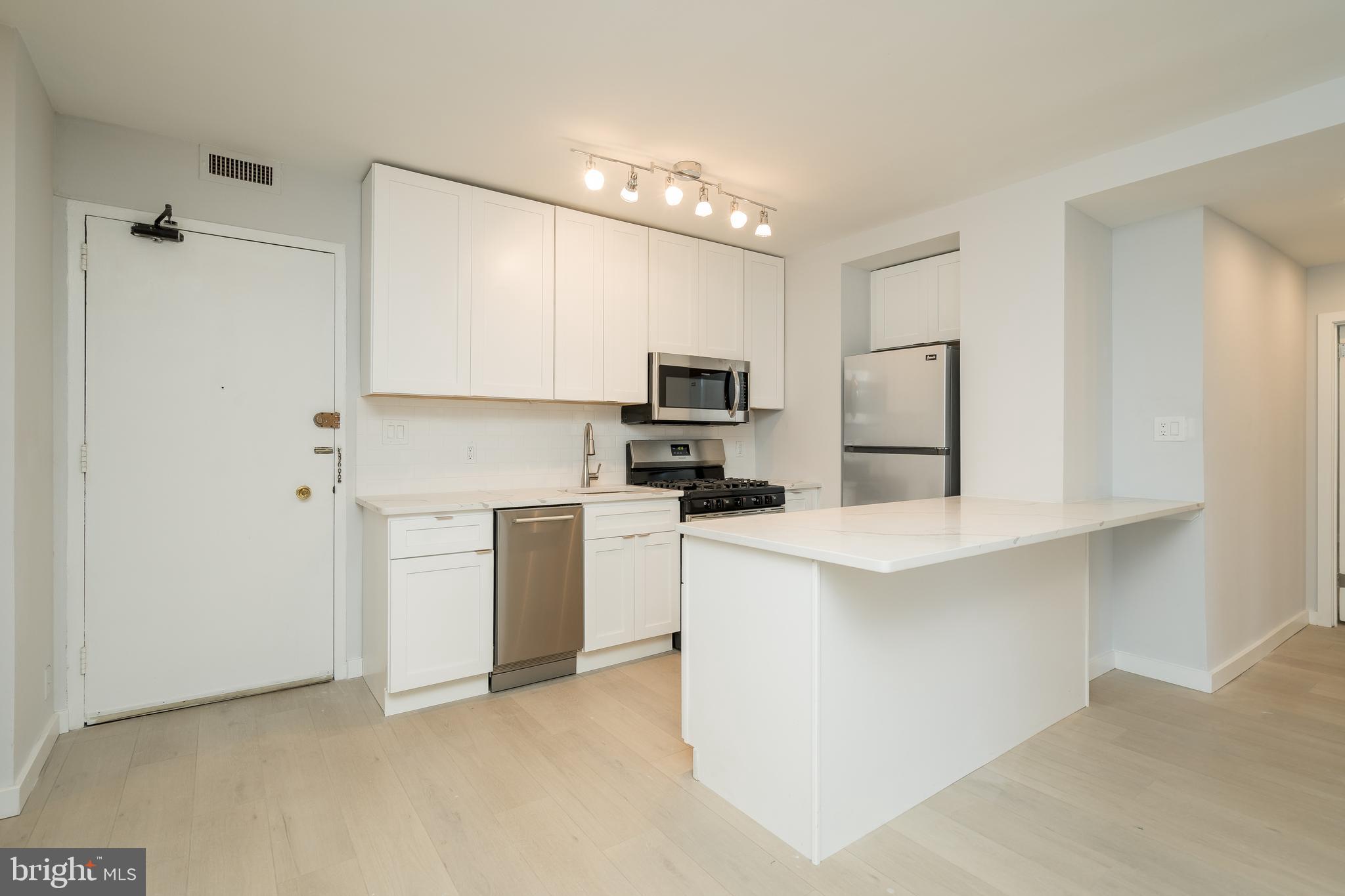 Bright and spacious renovated two bedroom, two bathroom residence with gorgeous wood floors available at The Wellington, located on Rittenhouse Square! The home features an open layout with a beautiful modern kitchen overlooking the living/dining area. The updated kitchen boasts sleek white cabinetry, quartz countertops, subway tile backsplash, stainless steel appliances, and a breakfast bar. The sun-drenched living area is lined with an entire wall of windows, providing excellent natural light. The bedrooms are spacious with great closet space. Both bathrooms are beautifully updated. There is also in-unit washer/dryer. The Wellington is a pre-war apartment building located on Rittenhouse Square offering a 24 hour doorman, on-site management, and access to a nearby fitness center at 1845 Walnut.