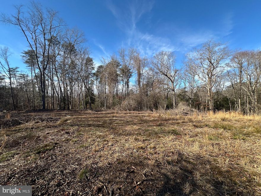 Discover nearly 26 acres of private, wooded land in Charles County, Maryland, zoned Rural Conservation and offering exceptional potential for a custom home, family compound, or recreational retreat. Encompassing 25.971± acres, this property is accessed by a right-of-way dirt road off Masons Spring Road, beginning at a gated driveway entrance that leads back to the start of the tract. The property is predominantly wooded with a healthy mix of mature hardwoods and softwoods, creating both privacy and natural beauty. Approximately midway through the property, an internal road turns left to a cleared area positioned on one of the higher elevations of the tract. This cleared homesite location features multiple approved perc sites, along with an older perc that would require reevaluation, providing multiple potential building options. The existing woods road continues around the backside of the property to a neighboring tract. Subtle elevation changes add character and natural drainage, with the elevated clearing offering an ideal setting for a future home. For outdoor enthusiasts, the property shows strong signs of whitetail deer activity, including numerous rubs and scrapes, making it an appealing recreational and hunting opportunity. Electric service is currently run to improvements on a neighboring property, potentially providing an opportunity for easier future connection, subject to buyer verification and utility company approval. While the property itself has not had a recent boundary survey completed, adjoining landowners have obtained recent surveys that clearly outline the property’s boundaries. Whether you’re seeking privacy, hunting land, or a scenic homesite with acreage, this Charles County property presents a rare opportunity to own a substantial wooded tract with approved perc sites and strong residential potential.