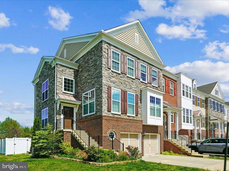 Nestled in the prestigious East Gate community, this exquisite end-of-row townhouse offers a harmonious blend of luxury and comfort, perfect for those seeking an elevated lifestyle. Built in 2012, this stunning residence spans 3,389 square feet and features a captivating Colonial and Transitional architectural style, showcasing a timeless brick and stone façade complemented by elegant vinyl siding. Step inside to discover a thoughtfully designed open floor plan that invites warmth and connection. The gourmet kitchen is a culinary enthusiast's dream, equipped with top of the line  LG ThinQ and Bosch stainless steel appliances, a spacious island, and a pantry for all your storage needs. The adjoining breakfast area is bathed in natural light, creating an inviting space for casual dining. For more formal occasions, the separate dining room, adorned with chair railings, wainscoating and crown moldings, sets the stage for memorable gatherings. The main level flows seamlessly into a cozy living area, where recessed lighting and wood floors enhance the ambiance. A convenient half bath adds to the functionality of this level. As you walk this level, you will encounter a wonderful room, perfect for a home office, studio, or even music room. Options are endless. Ascend to the upper floor, where you'll find three generously sized bedrooms, including a luxurious primary suite featuring a walk-in closet and a spa-like bathroom complete with a soaking tub and a walk-in shower-your personal retreat after a long day. Additional highlights include double-pane windows that ensure energy efficiency and tranquility, as well as ceiling fans that provide comfort throughout the seasons. The upper-level laundry room adds convenience to your daily routine. The lower level offers even more space! Equipped with lots of natural light, a fourth bedroom, full bath, generous recreational area that complements this outstanding home. Outside, the en unit rear fenced lot offers a sense of privacy while still being part of a vibrant community. Enjoy leisurely strolls along the sidewalks or take advantage of the community pool for relaxation and recreation. The attached garage with front entry and driveway parking provides ample space for vehicles and guests. Located less than 10 miles from the airport, this home combines accessibility with a serene suburban lifestyle. The association takes care of management, road maintenance, snow removal, and trash services, allowing you to focus on enjoying your beautiful new home. This property is not just a house; it's a lifestyle choice that embodies luxury, comfort, and community. Experience the perfect blend of elegance and practicality in this remarkable residence. Enjoy the single-family feel while retaining the convenience of townhome living! Don't delay this decision. Make this one yours!!