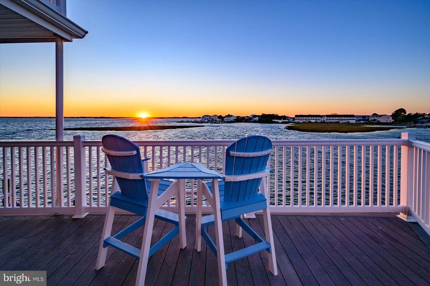 Don’t miss this incredible opportunity to own a rarely available 3BR/3BA bayfront townhome in North Ocean City featuring two deeded boat slips, a two-car garage, and breathtaking sunset views over deep water.  From the moment you walk in the front door, you’ll be captivated by panoramic bay views that stretch in both directions. The first floor features a beautiful bayfront bedroom with an upgraded full bath and a second family room that opens to a wraparound deck — perfect for relaxing or entertaining by the water. The main living level boasts a spacious family room with stunning bay views that flow seamlessly into an expansive gourmet kitchen — complete with a bar area, large pantry, abundant cabinet space, and granite countertops. A chef’s delight! The dining area overlooks the bay, and the deck off the family room provides the ideal spot to enjoy cool breezes and memorable crab feasts. Upstairs, you’ll find a guest bedroom with a private en suite bath featuring a stall shower and large walk-in closet. The primary suite is a true retreat — spacious and overlooking the bay, with a spa-like bath including an upgraded shower, soaking tub, and a huge walk-in closet. For the boating enthusiast, this home is a dream come true with two deeded boat slips, a dock, stee bulkhead and a pier for easy access to open water.  Experience some of the best fishing in Ocean City off the pier at the Fenwick Ditch.  The two-car garage provides plenty of storage for all your beach and boating gear. Conveniently located close to restaurants, shops, and Fenwick Island, this is coastal living at its best!