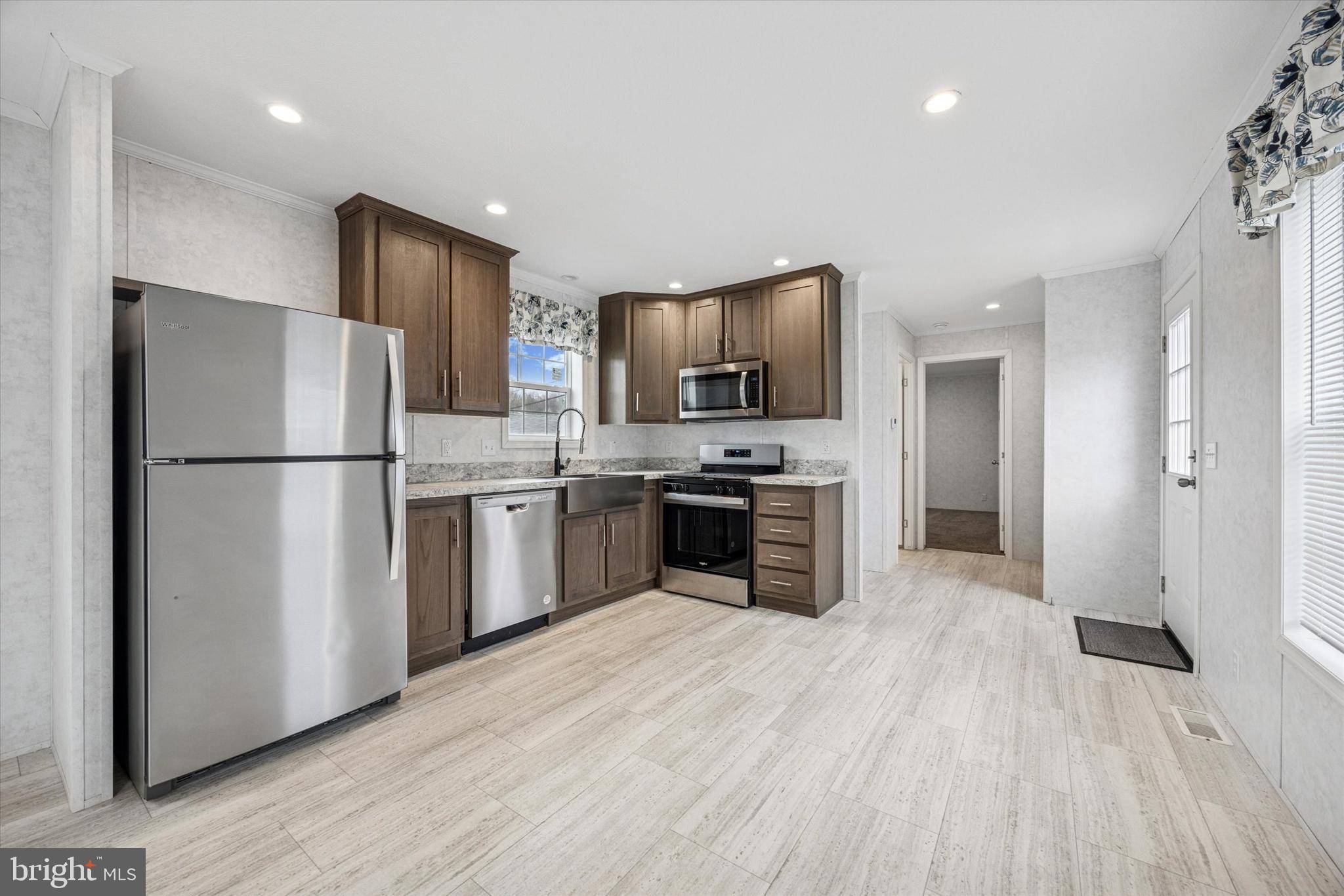 This beauty is almost BRAND SPANKING NEW! It is a 2024 model (14'wide x 64 long), and the owner only lived in it for less than 6 months! The light and bright luxury vinyl plank runs throughout the home (with the exception of the bedrooms which are carpeted). The living room and kitchen have a completely open concept so you can use your imagination to furnish the rooms any way you choose. The kitchen has plenty of cabinets, countertop was replaced by current owner, and all kitchen appliances are included. There is a front bedroom with a full hall bath and a gorgeous 2nd bathroom with tile and full glass doors adjacent to the 2nd bedroom in the rear of the home. This house is fresh and clean, and completely pristine inside and out! Come see!
( Manufactured home loans are acceptable but homes not eligible for a mortgage since it is a lot lease and you do not own the land)