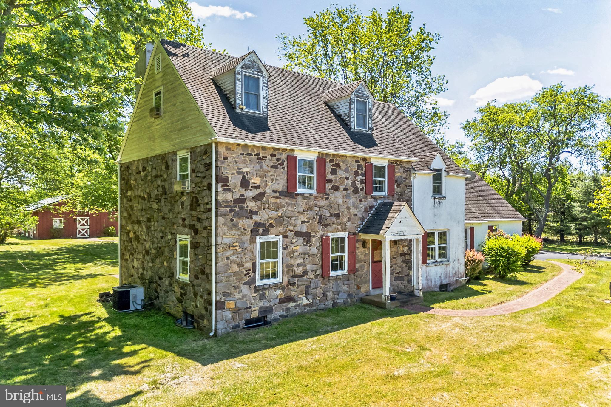 Be the proud new owner of 526 Pineville Road and realize the full potential of this idyllic 7.74-acre scenic and secluded property near Jericho Creek, with possible subdivision opportunities. An impressive tree-lined driveway leads to acres of open field as you approach the home. Restore this stone-front Bucks County Farmhouse as primary residence, or an accessory-use guest house/in-law residence for the new construction project of your dreams. A welcoming front portico greets guests and leads to a main foyer entry, flanked by a formal living room with custom built-in bookshelves and an ample dining room filled with an abundance of natural light. 1-inch thick oak flooring and decorative chair rail extends throughout nearly every room on the 1st and 2nd floor of this charming 3-story home. Exposed ceiling beams can be found in both the kitchen and gathering room, which is enhanced by an oversized stone fireplace and features direct access to the brick rear patio. The well-appointed eat-in kitchen offers recessed lighting, exposed beams and plenty of cabinet space. Just off the kitchen, a convenient laundry room with pocket door, a half bath, access to the attached 2-car garage and an additional rear exit can also be found. Upstairs, an expansive 2nd floor landing is a flexible space that can easily function as an open den, reading nook or play area. The main bedroom suite hosts a sitting room with skylights, large walk-in closet and a full bathroom with double vanity, clawfoot tub, and tile shower with glass enclosure. 2 additional bedrooms (one with triple closets) and a full bathroom complete this level. A 3rd floor offers additional living space with 2 large bedrooms, 1 full bathroom, and plenty of extra closet/storage space. Additional upgrades include a new water heater in 2021, and SealFilter installed on all gutters with a lifetime transferable warranty. Outside, the brick patio overlooks a picturesque rear yard--perfect for entertaining, gardening and observing wildlife. Sold oak stables, in the rustic 1000 square foot barn, have been converted into a work and meeting space--complete with 4 zone radiant heat, eat-in kitchen, full bath, solar panels that power the entire house and barn, a projector screen and even an MIT grade chalkboard. In addition, an attached 4-car garage (not included in the finished barn sq/ft) contains a whole house diesel generator and an electric winch. Enjoy the serene privacy of this special property while remaining close to area attractions—easy access to Philadelphia, Allentown/Bethlehem, and New Jersey and New York via Rte. 202. In close proximity to George School and community events, shops, dining and nightlife in historic Newtown, Doylestown & New Hope Boroughs. Book your private showing today!