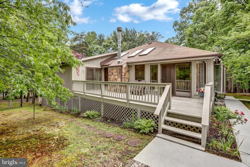 Welcome to this quaint well kept Contemporary Home located in The Woods! *BRAND NEW LENNOX HVAC SYSTEM w/10 YR WARRANTY* This beautiful home boasts 2200+ Sq. Ft. of finished living space on 2 main levels. Main level features an open light filled layout including the Gourmet Remodeled Kitchen with High end Cabinetry, quartz counter tops, island with butcher block top, built-in Microwave, hardwood flooring, and adjoining breakfast room area which opens to the spacious Living Room with stone fireplace with brand new upgraded insert, vaulted ceilings, and sky-lighting throughout offering the perfect place to gather with family and friends! Main Level Primary Owner's Suite is a dream- including a built in office area, sitting room, fireplace, walk-in closet, and adjoining luxury bath with tile, separate vanity stations, and oversized tile shower with bench seating.  An additional Junior Bedroom is also located on the main living floor. Sunroom with glass surround for enjoying those chillier days or relax on the screened in porch and listen to the sounds of surrounding nature. Upper level has a loft/2nd Bedroom area. Home has 2 Cedar closets perfect for preserved storage! The 2 car attached garage is built-in to the lower level with access to the main dwelling. An additional over-sized detached garage can easily house your larger recreation vehicles including a a 40' RV with Hookup and dump station. Long paved driveway offers additional parking for guests as well. The Woods Resort has additional Class A Membership which can be purchased at closing to enjoy the amenities of the Woods Resort including pools, dining, and golf! Comcast internet is available!!