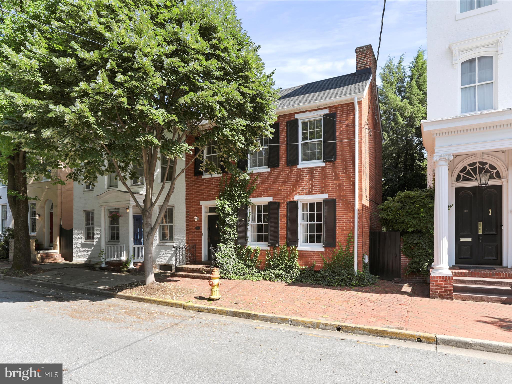 An exquisite opportunity to own this charming and meticulously maintained home just steps from Baker Park and only half a block from the heart of downtown Frederick. Brimming with character and timeless appeal, this home is sure to captivate every buyer who walks through the door.
Enter through the elegant foyer, highlighted by a stunning turned staircase. The home offers four spacious bedrooms and an updated full bath featuring new tile, a modern stand-up shower, and a stylish new sink. The main level half bath has also been updated with new flooring, decorative wallpaper, a vintage-style hand sink, and a unique picture box window that adds even more charm.
Freshly and professionally painted throughout (2022), this home includes a new roof replaced 50-year life (2022), two new central air conditioning (2022), tankless water heater installed (2022) and showcases refinished original wide-plank hardwood flooring that gleams across the entire residence. Additional features include custom window shutters, built-in shelving, and a covered balcony offering a cozy outdoor retreat. A walk-up, floored attic provides ample extra storage, also the basement with interior access comes equipped with a newly redone cement floor creating additional storage space.
The front formal living room welcomes you with a fireplace and leads seamlessly to the formal dining room, with a second fireplace where the updated lighting creates the perfect ambiance for entertaining. The functional eat-in kitchen offers generous counter and cabinet space, along with access to the rear yard and patio.
Enjoy peace and tranquility in the private, professionally landscaped backyard, complete with a brick hardscaped patio and privacy fencing. A deeded covered parking space just around the corner adds convenience and value. The rear walkway provides additional access directly to the street.
Take advantage of all that downtown Frederick has to offer, with dining, entertainment, and local attractions just a short walk away. This is a truly special property that blends historic charm with thoughtful updates in one of Frederick’s most desirable locations. You will not be disappointed.