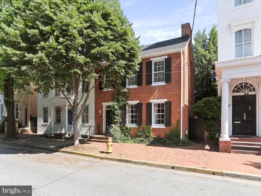 An exquisite opportunity to own this charming and meticulously maintained historic semi detached with additional gated street access from the back yard.  This home is  just steps from Baker Park and only half a block from the heart of downtown Frederick. Brimming with character and timeless appeal, this home is sure to captivate every buyer who walks through the door.

Enter through the elegant foyer, highlighted by a stunning turned staircase. The home offers four spacious bedrooms and an updated full bath featuring new tile, a modern stand-up shower, and a stylish new sink. The main level half bath has also been updated with new flooring, a vintage-style hand sink, and a unique picture box window that adds even more charm.

Freshly and professionally painted throughout (2022), this home includes a new roof replaced 50-year life (2022), two new central air conditioning (2022), tankless water heater installed (2022) and showcases refinished original wide-plank hardwood flooring that gleams across the entire residence. Additional features include custom window shutters, built-in shelving, and a covered balcony offering a cozy outdoor retreat. Tons of closet space, including a walk-in closet.  A walk-up, floored attic provides ample extra storage, also the basement with interior access comes equipped with a newly redone cement floor creating additional storage space.  

The front formal living room welcomes you with a fireplace and leads seamlessly to the formal dining room, with a second fireplace where the updated lighting creates the perfect ambiance for entertaining. The functional eat-in kitchen offers generous counter and cabinet space, along with access to the rear yard and patio.

Enjoy peace and tranquility in the private, professionally landscaped backyard, complete with a brick hardscaped patio and privacy fencing. A deeded covered parking space just around the corner adds convenience and value. The rear walkway provides additional access directly to the street.

Take advantage of all that downtown Frederick has to offer, with dining, entertainment, and local attractions just a short walk away. This is a truly special property that blends historic charm with thoughtful updates in one of Frederick’s most desirable locations. You will not be disappointed.