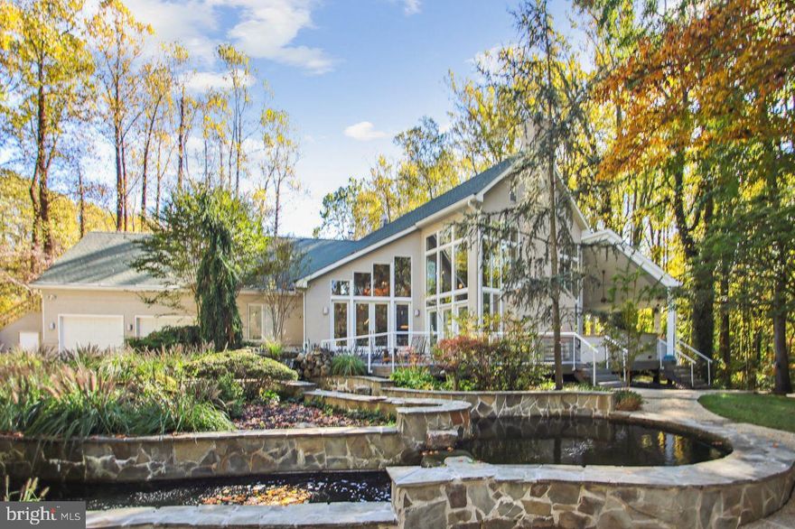 SERIOUS PRICE REDUCTION.  OF $150,000.   SERIOUS SELLER.  Welcome to Randalls Trust, a small enclave of custom homes  located in an area of farmettes and estate homes.  Only 20 minutes to Annapolis and convenient to BWI and commuting routes.
You are welcomed to this contemporary masterpiece by a dramatic two story foyer leading to an open living  area  incorporating  a step down living room , a dining area with quality built in cabinetry and a custom bar.  An amazing professional grade chefs' kitchen  overlooks it all!  There is custom built in cabinetry throughout the home.  From here we can exit to expansive decking with a stainless outdoor kitchen. This all overlooks a private backyard oasis  including a beautiful pool, koi pond and waterfall.  The home is truly an entertainers dream. The main floor is completed by three bedrooms including an expansive primary suite exuding luxurious comfort and an ensuite bath.  Also on this floor is  the laundry area  and mudroom adjacent to the oversized 2 car garage. There is an additional single car garage.
On the second level is a dramatic open gallery overlooking the living level below. Here we have built in shelving and cabinetry making this a  space adaptable to many possibilities.  Two oversized bedrooms  complete this floor. One of the bedrooms has an outside exit leading to a stairway to the parking /garage area.  (Possible professional office?) The lower level includes another full bath with a sauna. Otherwise unfinished, a huge space adaptable to many purposes. To complete the picture, there is a gated entry to the rear parking area and a detached single garage perfect for the automotive hobbyist, There is a whole house generator just in case! New carpet and fresh paint in much of the home. Home warranty.
Truly a remarkable home that must be seen to be appreciated.