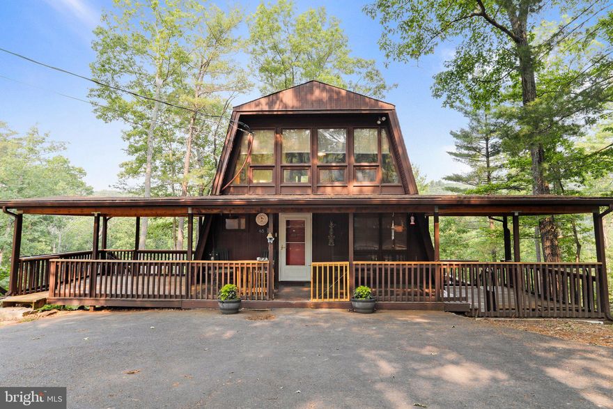 Well-maintained lakefront cabin in Sleepy Hollow! Featuring 4 bedrooms, 2.5 baths, situated on 1.21 acres. Family room with wood stove, high ceilings, dining and eat-in kitchen. Loft area with bedroom and half bath. One bedroom on main level. Basement with two additional bedrooms and full bath. Window units for cooling, electric baseboard for heating. Outdoor shower. Sold as-is. Nice view of the lake with private lake access, private dock included.  Make this your perfect mountain retreat or forever home! Close to The Woods Resort for additional outdoor recreation and Potomac River. Schedule your tour today!