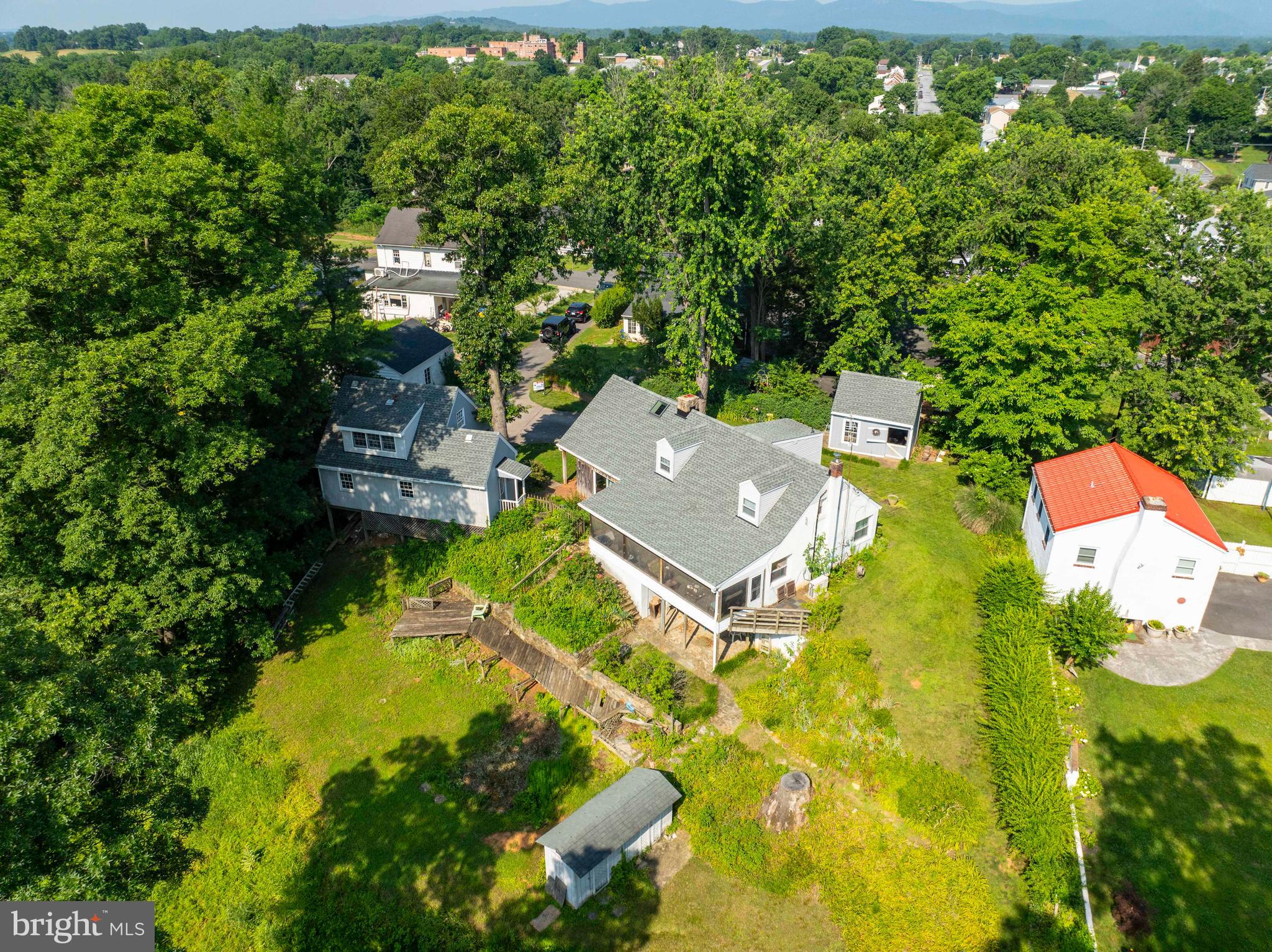 Contemporary In-Town Retreat with Mountain Views on 1.02 Acres
A rare opportunity to own a contemporary home nestled in the heart of town—featuring spectacular mountain views and situated on an expansive 1.02-acre lot (comprising 5 total lots). This versatile property offers exceptional value and boundless potential for its next owner.
✨ Property Highlights
Approx. 1,763 finished sq. ft. above grade
3 Bedrooms | 1.5 Bathrooms
Multiple living areas including a family room, formal dining room, and den/office
Two fireplaces: a stunning stone fireplace and additional woodstove with stone surround
Large screened-in porch for all-season enjoyment of the mountain scenery
Unfinished basement for added storage and expansion potential
🍽️ Kitchen & Living
The spacious kitchen offers rich wood cabinetry and granite countertops, with plenty of room for food preparation and eat-in dining. Natural light pours in through numerous large windows, creating a bright and welcoming environment.
🛏️ Main Level Convenience
A main-level bedroom and a half bath with a laundry area provide practicality and accessibility. The additional den or office adds flexibility for remote work, hobbies, or quiet retreat.
🛋️ Upper Level
Upstairs includes a small sitting area/landing, two additional bedrooms, and a full bath, ideal for family or guests.
🌿 Outdoor Oasis
Enjoy abundant outdoor space with:
Stone patio, covered porches, and screened-in porch
Gardening/potting shed with upper-level storage
2-car detached garage with additional upper-level space
Concrete driveway offering generous parking
Attractive stonework accents including walkways and walls
🌟 Location & Lifestyle
This rare in-town location offers the best of both convenience and tranquility. Just minutes from:
Shenandoah River
Local wineries & golf courses
I-66 access
Shops and restaurants
High-speed internet available
No HOA
