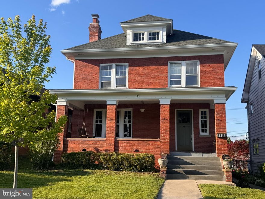 Timeless Brick American Foursquare on King Street – Walkable Location, Modern Comforts

Nestled in the heart of Martinsburg's historic district, 1216 W King Street is a classic all-brick Foursquare that blends period charm with thoughtful updates. This stately two-story home offers stunning curb appeal with its symmetrical façade, dormer windows, and an inviting front porch perfect for morning coffee or evening relaxation.

Step inside to discover beautifully preserved hardwood floors,  wood pocket doors, elegant trim, and original architectural details throughout. The foyer welcomes you with warm natural light, graceful woodwork, and a gently curved staircase. The spacious living room features a painted brick fireplace with decorative molding and a sparkling chandelier, while the adjacent dining room offers space for gatherings with abundant natural light and charming built-ins.

The kitchen is a cook’s delight, boasting white cabinetry,  new quartzite countertops, a farmhouse sink, and stainless steel appliances including a Jennair downdraft multi-fuel (gas range, electric stove with convection setting)—all thoughtfully arranged for efficiency and style. Upstairs, cozy bedrooms offer built-ins, and peaceful views of the surrounding neighborhood. The third-floor finished attic provides flexible space for an office, studio, or additional bedroom, with charming dormers and hardwood flooring.

The full bathroom is clean and classic with updated tile, and functional storage. Outside, the home is framed by a spacious lawn, sidewalk approach, new concrete stairs and a backyard ready for your vision.

Located just moments from downtown shops, schools, and commuter routes, this lovingly maintained home offers the ideal balance of historic beauty and modern livability.