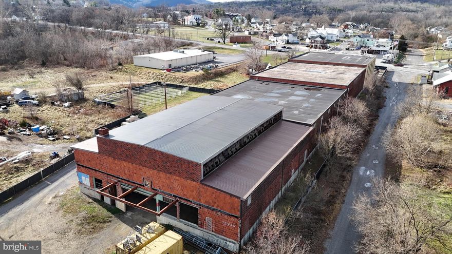 Investor Opportunity – 19 Apple Way, Paw Paw, WV 25434

Located in Morgan County near the Hampshire and Allegany County lines, this ±80,000 sq. ft. multi-warehouse commercial facility offers a rare acquisition opportunity with built-in tenant stability and long-term development flexibility. Currently occupied by Tenant, a nationally recognized facility, the property has received over $800,000 in capital improvements tailored to high-performance operational needs.

Property Overview:

• ±80,000 sq. ft. total across four distinct warehouse structures• Front Warehouse: ±10,000 sq. ft.
• Middle Warehouses (2 & 3): Connected, ±25,000 sq. ft. per floor (two floors)
• Rear Warehouse: ±14,000 sq. ft. ground-level

• Zoned for commercial/light industrial use
• Fully fenced perimeter with privacy mesh ($100,000 investment)
• 2TB security system with full camera coverage (interior/exterior) and alarms on all access points
• Gated entry and ample parking
• Located near regional transport routes and tactical training corridors


Tenant & Lease Details:

• Current tenant willing to sign long-term lease
• Tenant occupies partial space—remaining square footage available for lease or expansion
• Facility supports modular use, multi-tenant occupancy, or phased development
Tenant is also willing to vacate


Development Potential:

• Owner initiated subdivision into three separate parcels
• Preliminary documentation available
• Ideal for tactical training, logistics, light manufacturing, or specialty service providers


Offering Terms:

• Property offered for investor acquisition
• Flexible terms available for qualified buyers
• Site available as-is with subdivision plans in progress


This listing represents a turnkey opportunity for investors seeking a high-capacity, partially leased commercial asset with proven tenant investment and long-term growth potential. With modular infrastructure, subdivision flexibility, advanced security, and a committed tenant, 19 Apple Way is positioned for scalable returns and operational versatility.