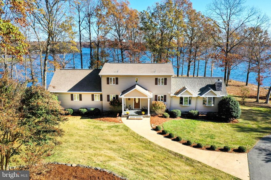 NEW PRICE on this Lake Anna Oasis. Paradise welcomes you at Serenity Shores on Lake Anna. Your peaceful escape from reality awaits you in this beautiful waterfront retreat, south of the 208 Bridge on the public side of Lake Anna.  Here you will enjoy incredible, panoramic views of the largest part of the lake.  Stroll on your very own premium point lot with over 600+ ft shoreline, already protected by beautiful riprap, alongside the clearest and deep water (10+ ft at the end of boathouse). Location is everything here, with sparkling Lake Anna as your focal point. Take a leisurely stroll down the stone path from the house to the large double-slip boathouse with marine decking, two electric boat lifts, an expansive sun deck, storage room, and a screened-in covered room to relax and unwind over the tranquil waters of Lake Anna. You'll feel your stress drift away the moment you drive down the long paved circular driveway. Very private and peaceful location makes this property the perfect get-a-away.  This retreat offers over 3,200+ finished SQFT and features 5 BDRMS, 3.5 BTHS. Granite countertops, tile and hardwood flooring, elegant vaulted ceilings, a stone gas fireplace in the family room and a separate living room with a wood burning stove. Spacious main level primary ensuite has its own private deck, gas fireplace, large walk-in closet, jetted tub and separate shower. There is one other main level lakeside bedroom and half bath on the main level. The upstairs has two large bedrooms and a full bath. Finished walkout basement has a 4th bedroom, full bath and a family room/rec room with a wet bar.  Covered front porch with slate flooring and tongue & groove ceiling and a large back deck over looking the water.  Oversized detached garage/workshop with a lean-to.  Come see for yourself and start making your memories here with your family and friends. High speed fiber internet is available here and short term rentals are permitted in the neighborhood. This home has a true 5-bedroom septic (rare). Great lake location by car and boat! Just minutes from the New Bridge shopping center for groceries, Verizon store, ABC, nail salon and just a short drive to local restaurants, Lake Anna Taphouse, Lake Anna Winery & other local breweries and less than two hours from D.C.