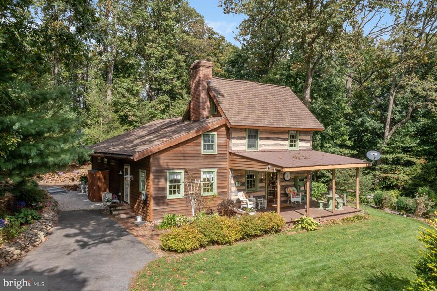 Looking for a quaint secluded farm to call your own? You won’t want to miss this property! A moved and reconstructed charming 1840’s log house with modern additions is the centerpiece of this small farm set on almost 18 acres among the trees in northern Carroll County, Maryland.  Main floor living includes a very large bedroom/great room with two-story vaulted ceiling and skylights, full bathroom with laundry facilities, a living room with log and chinking walls, and a brand-new kitchen.  Two additional bedrooms and another bath complete the two upper floors of the log cabin, and a basement provides additional living or storage space.  Lots of windows all around gives great panoramic views.  Enjoy front porch views of yard, pasture, fields and the valley, or side porch seating with a view of the forest.  The gravel driveway winds through trees to this secluded property which has a peaceful, tranquil air.

The farm includes a small barn with feed room, two fenced pastures which currently contain sheep, fiber goats and a mini-donkey as their guardian, and the potential for additional pasture in a large grassed area.  The current owner has added in a raised bed garden, fruit bushes, lavender and several fruit trees.  Wild raspberries and blackberries are abundant on the farm, which is approximately half in trees of both native and other varieties, and half cleared land. Other outbuildings include a detached garage, a structure with renovation potential and a run-in shelter in the pasture.  The farm’s apiary containing four colonies of bees takes advantage of the farmland and wildflowers in the area.  There are two fields currently leased to a neighboring farmer who plants corn and soybeans yearly.

Large number of improvements over the last three years include new kitchen, all PVC plumbing, additional heating and cooling in the form of ductless minisplits, upgraded electrical, new well pump, new well pressure tank, and much, much more. 
If you are looking for a small farm to call your own, this is the place.  The peace and quiet of the country and your own small farm, but a short drive to all the amenities, with amazing neighbors,  this is one of Carroll County’s prettiest places to live.