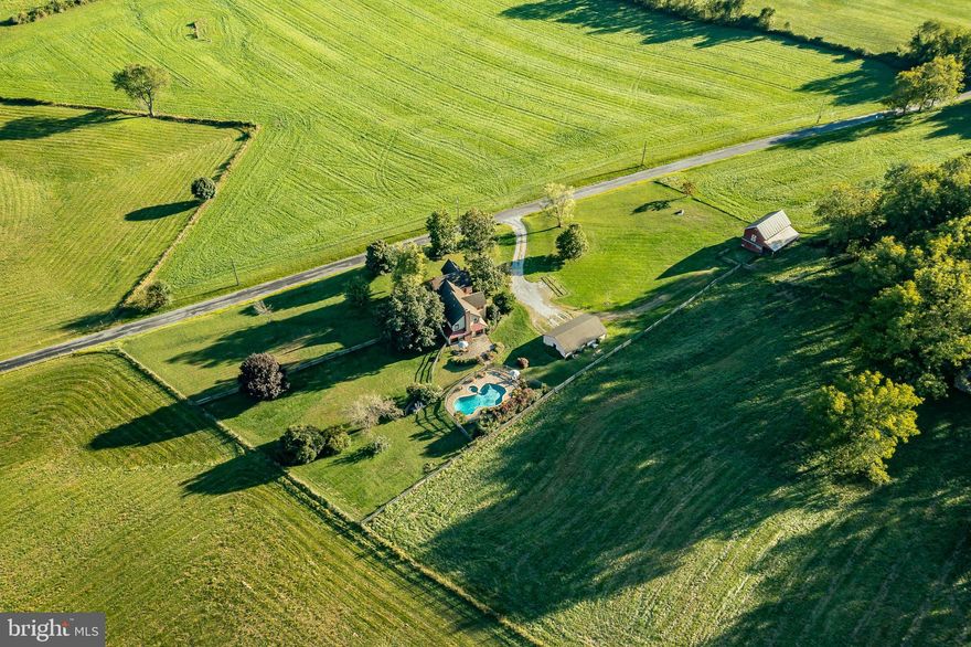 Set on 33 acres in the heart of Unionville’s famed equestrian area and right next to Plantation Field, this is a rare opportunity to live in the prettiest valley in the countryside. At the epicenter of 35,000 contiguous acres of conserved land, the four bedroom, two and a half bath home is comprised of an older section constructed c.1900 with a c.2001 custom addition that provides abundant light and airiness. The first level features a gourmet Kitchen with high end appliances, plenty of granite counter space, an abundance of cabinet storage. The open concept Kitchen-Family room  has a fieldstone constructed Rumford fireplace flanked by two atrium doors that open to a large Patio constructed with block pavers leading to the private in-ground Pool, with views across the property. Numerous windows floods this room with volumes of natural light. The c.1900 section contains a lovely Living Room with access to the south facing front porch. Also accessing the front porch is a quiet Office which has become a “Must Have”. There is also a cozy Den. Upstairs is a restful Primary Suite set in the c.2001 addition that has a  gorgeous Full Bathroom complete with an antique “Ball and Claw” tub. Three additional bedrooms and a hall bathroom, plus the home’s laundry, round out the upper level. The farm also includes a detached three car garage and a three stall stable with loft storage above as well several fenced paddocks. There is the potential for numerous paddocks to be added, plenty of level land to add a ring or expand the barn. The Agricultural Conservation Easement does not preclude an indoor riding arena and allows for minor subdivision and the creation of an additional residence. Farms in this remarkable location rarely come on the market. Located in the nationally ranked Unionville-Chadds Ford School District and enjoying low taxes.