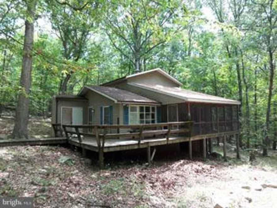 Sold As-Is, How Is.  Will not qualify for financing,  CASH ONLY!! ALL inspections if any to be done before offer is submitted, Electric is turned off. Would make a good Flip or project for Jack of ALL Trades. Well pump worked in 2013, broken line kept water from entering home.  Large retreat home with 4 bedrooms, (2BR septic) 2 baths, dining room, huge living room with cathedral ceilings, a good size kitchen loaded with cabinets, wrap around deck with screened porch, all nestled in the trees on 5 acres not far from the river.  If you need to rely on independent inspections this is not the house for you.