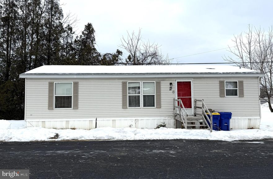 This conveniently located double wide features an open floor plan with a fully equipped kitchen, dining room and living room with an electric fireplace.  The primary suite with a full bath and walk in closet is located on the opposite side of the house from the second bedroom and full bath.  A laundry room, with a washing machine and clothes dryer included, in located off of the kitchen.  The house does need some updating but is priced well for economical living.