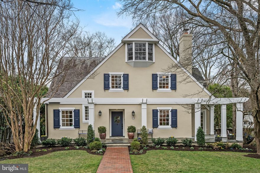 An elegant gem of a home in the heart of Chevy Chase Village! This one-of-a-kind English country cottage was reimagined by renowned architect Robert Bell to create soaring light-filled interiors. The tall-ceilinged great room boasts an updated chef’s kitchen, eating alcove, and gracious living room facing on a private rear patio and lawn. French doors flanking a hand-carved wooden hearth open onto a soaring, barrel-ceilinged study with vaulted windows framing sunset views. The cathedral-ceilinged primary bedroom features three exterior exposures to light and outdoor greenery: floor-to-ceiling French doors open onto a Juliet balcony over the southern-facing back yard, interior double doors access a second balcony overlooking the barrel-ceilinged study, and the opulent bath includes steam, jacuzzi and generous window light. Three of the five bedrooms feature en suite baths, including a top floor suite ideal for a teenager, or private office. This gracefully designed and versatile home offers separate spaces for family living, remote work, and hosting out-of-town guests.  Featuring two wood-burning fireplaces, front and back flagstone decks, second-floor laundry room, a two-car garage and finished basement with ample storage, it's just two blocks from Connecticut Avenue shops and easy walking to Friendship Heights Metro and stores.