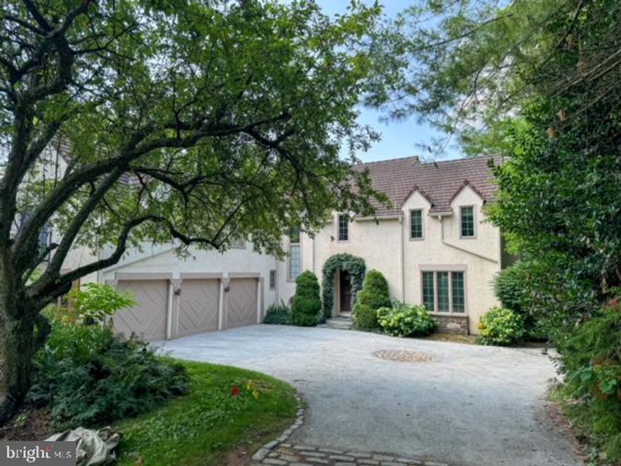 Natural light permeates this beautiful 4 bedroom, 4 and a half bath French Colonial in coveted Bryn Mawr. This wonderful Main Line home sits on almost an acre of ground and has the perfect flow and modern floorplan that is so desirable for today’s contemporary lifestyle.  The exquisite views overlooking the vast property of an adjoining estate are quite breathtaking and are enjoyed from various rooms in the home as well as from the huge deck that is accessible from both the open-plan kitchen/breakfast/great room area, and the formal dining room.  A large 2-story entry foyer leads directly to the formal dining room with beautiful hardwood floors, custom built-in cabinetry and buffet for serving, that spans the length of the room. This gorgeous room is flooded with light and can accommodate an expansive dining table to enjoy formal dinner parties or large family gatherings and celebrations.  To the right of the entry is a large, bright living room with fireplace, hardwood floors, large windows, and French doors to a small balcony. The central gathering point of this home is the open-plan kitchen with island, breakfast area, and a dramatic 2-story great room with soaring vaulted ceiling, fireplace and custom-built-ins.  A powder room and convenient first-floor laundry room, which includes a laundry chute from the main suite bathroom, complete the first level.
The second floor has a loft area with built-ins that overlooks the great room.  The primary suite is charming with interesting architectural detail including French doors to a small balcony overlooking the grounds. A long hallway of fitted closets as well as a large, custom fitted walk-in closet offer plenty of storage. The marble bathroom has double sinks, ‘his and her’ separate toilet rooms, Jacuzzi tub, stall shower and heated flooring. There are 3 additional bedrooms and 2 more bathrooms on this level.
The finished, ‘above ground’ lower level with newly installed rugs adds fabulous additional living space with numerous possibilities! There is also a full bathroom with sauna, a small kitchenette, a small room set aside as a wine closet and additional rooms for ample storage.
Other special features include an oversized 3-car attached garage, whole house generator, cedar closet, security alarm system, award winning Lower Merion Schools, minutes from I-76 and I-476, close to center city, King of Prussia and the wonderful town of Bryn Mawr, with its great restaurants, boutiques, antique stores and Ludington Library.
Total square footage including the walk-out lower level is 4,742 sf (public records).
Some fixtures and art pieces presently in the home are negotiable.