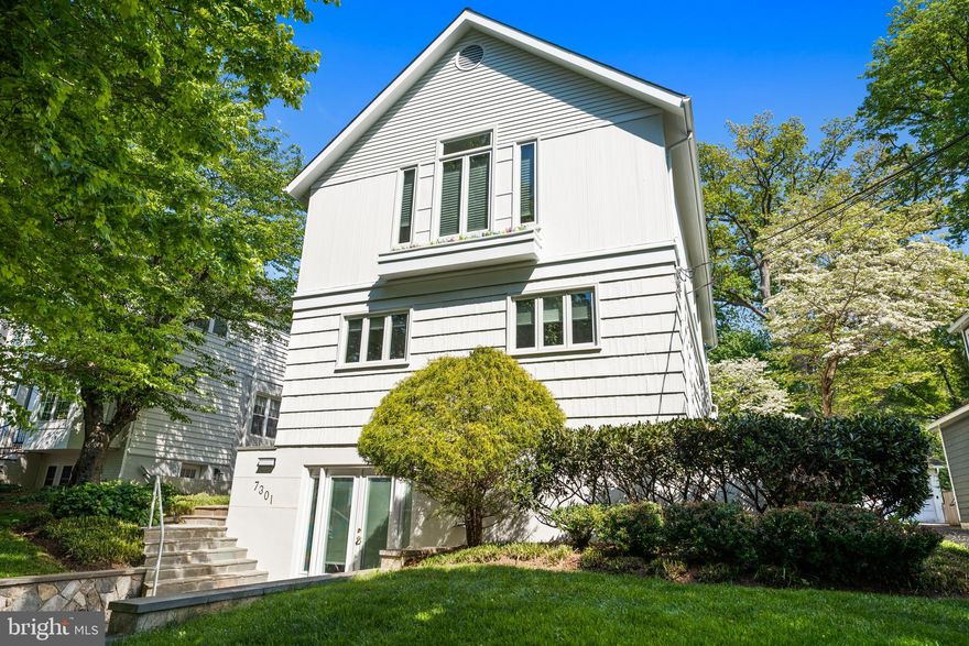 Step into the bright, unexpected spaces of 7301 Summit Avenue and immediately understand why this home stands apart. This contemporary five-bedroom, three-and-one-half-bath residence in sought-after Martin’s Additions offers something increasingly rare: light, openness, flexibility, and a floor plan that truly adapts to modern life. Meticulously maintained with exceptional flow and natural light, the home features an open-concept layout, beautiful hardwood floors, recessed lighting, and two fireplaces, all wrapped in a setting that feels both refined and remarkably livable.
The flagstone walkway invites you into a home that continually unfolds in surprising ways. At the center is the recently renovated gourmet chef’s kitchen with a center-island breakfast bar, state-of-the-art appliances, sleek tile and lighting, along with a sunlit dining space perfect for sipping morning coffee or sneaking a late-night snack. The oversized great room, framed by expansive windows and anchored by a fireplace, is truly the heart of the home. Adjacent to the kitchen is the formal dining room with enough space for gatherings both large and intimate.
Perhaps most compelling is the flexibility of the layout itself. Two main-level bedrooms, served by a full hall bath, can effortlessly function as home offices, den spaces, guest rooms, playrooms, or multigenerational living areas, creating a level of adaptability rarely found in the neighborhood. The separation from the upstairs primary and secondary bedrooms adds both privacy and functionality, allowing the home to evolve naturally alongside changing lifestyles.
Upstairs, the primary suite serves as a welcoming retreat with two generously sized closets, including a walk-in closet, and a spacious en-suite bath with dual sinks and a soaking tub. A second-floor family room, ideal for homework, reading, movie nights, or quiet relaxation, features a fireplace and creates a natural separation between the primary suite and two additional bedrooms. Each bedroom is outfitted with large windows, custom closets, hardwood floors, and enough space for homework, hobbies, or crafts. A full bath with a skylight completes the level, while the attic above provides valuable additional storage.
The lower level continues the home’s theme of flexibility and functionality, featuring a recreation room equally suited for play, gathering, workouts, hobbies, or casual living, with access to the front driveway and easy indoor-outdoor flow into the front yard. A powder room, laundry area, and ample storage complete the level, while a rear storage shed adds even more utility to the backyard.
The large landscaped backyard provides a very private, open backdrop for everyday living. Flowering gardens and leafy green surroundings soften the busy edges of life, with birds chirping, fireflies flickering at dusk, and sprinklers running on warm summer evenings. Whether entertaining friends, grilling, dining al fresco, or simply relaxing outdoors, this backyard is a true retreat.
Tucked within the tranquil Village of Martin’s Additions, 7301 Summit Avenue enjoys close proximity to Brookville Market, La Ferme, neighborhood parks, and nearby schools. This is one of Chevy Chase’s most beloved communities, where tree-lined streets, timeless architecture, weekend walks to Avalon Theatre or Rock Creek Park, and a true neighborhood feel continue to define daily life.