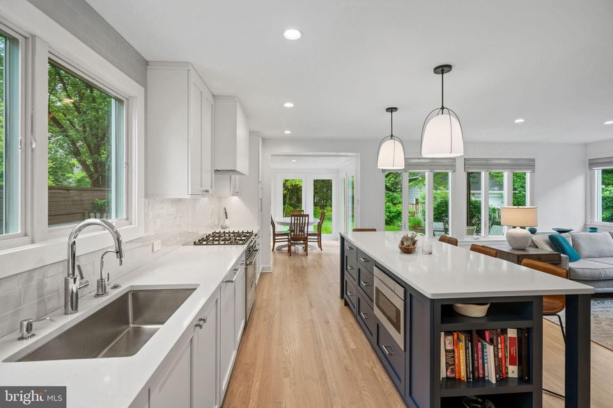 Step into the bright, unexpected spaces of 7301 Summit Avenue and immediately understand why this home stands apart. This contemporary five-bedroom, three-and-one-half-bath residence in sought-after Martin’s Additions offers something increasingly rare: light, openness, flexibility, and a floor plan that truly adapts to modern life. Meticulously maintained with exceptional flow and natural light, the home features an open-concept layout, beautiful hardwood floors, recessed lighting, and two fireplaces, all wrapped in a setting that feels both refined and remarkably livable.
The flagstone walkway invites you into a home that continually unfolds in surprising ways. At the center is the recently renovated gourmet chef’s kitchen with a center-island breakfast bar, state-of-the-art appliances, sleek tile and lighting, along with a sunlit dining space perfect for sipping morning coffee or sneaking a late-night snack. The oversized great room, framed by expansive windows and anchored by a fireplace, is truly the heart of the home. Adjacent to the kitchen is the formal dining room with enough space for gatherings both large and intimate.
Perhaps most compelling is the flexibility of the layout itself. Two main-level bedrooms, served by a full hall bath, can effortlessly function as home offices, den spaces, guest rooms, playrooms, or multigenerational living areas, creating a level of adaptability rarely found in the neighborhood. The separation from the upstairs primary and secondary bedrooms adds both privacy and functionality, allowing the home to evolve naturally alongside changing lifestyles.
Upstairs, the primary suite serves as a welcoming retreat with two generously sized closets, including a walk-in closet, and a spacious en-suite bath with dual sinks and a soaking tub. A second-floor family room, ideal for homework, reading, movie nights, or quiet relaxation, features a fireplace and creates a natural separation between the primary suite and two additional bedrooms. Each bedroom is outfitted with large windows, custom closets, hardwood floors, and enough space for homework, hobbies, or crafts. A full bath with a skylight completes the level, while the attic above provides valuable additional storage.
The lower level continues the home’s theme of flexibility and functionality, featuring a recreation room equally suited for play, gathering, workouts, hobbies, or casual living, with access to the front driveway and easy indoor-outdoor flow into the front yard. A powder room, laundry area, and ample storage complete the level, while a rear storage shed adds even more utility to the backyard.
The large landscaped backyard provides a very private, open backdrop for everyday living. Flowering gardens and leafy green surroundings soften the busy edges of life, with birds chirping, fireflies flickering at dusk, and sprinklers running on warm summer evenings. Whether entertaining friends, grilling, dining al fresco, or simply relaxing outdoors, this backyard is a true retreat.
Tucked within the tranquil Village of Martin’s Additions, 7301 Summit Avenue enjoys close proximity to Brookville Market, La Ferme, neighborhood parks, and nearby schools. This is one of Chevy Chase’s most beloved communities, where tree-lined streets, timeless architecture, weekend walks to Avalon Theatre or Rock Creek Park, and a true neighborhood feel continue to define daily life.