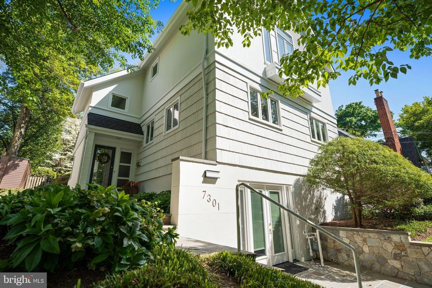 Step into the bright, unexpected spaces of 7301 Summit Avenue and immediately understand why this home stands apart. This contemporary five-bedroom, three-and-one-half-bath residence in sought-after Martin’s Additions offers something increasingly rare: light, openness, flexibility, and a floor plan that truly adapts to modern life. Meticulously maintained with exceptional flow and natural light, the home features an open-concept layout, beautiful hardwood floors, recessed lighting, and two fireplaces, all wrapped in a setting that feels both refined and remarkably livable.
The flagstone walkway invites you into a home that continually unfolds in surprising ways. At the center is the recently renovated gourmet chef’s kitchen with a center-island breakfast bar, state-of-the-art appliances, sleek tile and lighting, along with a sunlit dining space perfect for sipping morning coffee or sneaking a late-night snack. The oversized great room, framed by expansive windows and anchored by a fireplace, is truly the heart of the home. Adjacent to the kitchen is the formal dining room with enough space for gatherings both large and intimate.
Perhaps most compelling is the flexibility of the layout itself. Two main-level bedrooms, served by a full hall bath, can effortlessly function as home offices, den spaces, guest rooms, playrooms, or multigenerational living areas, creating a level of adaptability rarely found in the neighborhood. The separation from the upstairs primary and secondary bedrooms adds both privacy and functionality, allowing the home to evolve naturally alongside changing lifestyles.
Upstairs, the primary suite serves as a welcoming retreat with two generously sized closets, including a walk-in closet, and a spacious en-suite bath with dual sinks and a soaking tub. A second-floor family room, ideal for homework, reading, movie nights, or quiet relaxation, features a fireplace and creates a natural separation between the primary suite and two additional bedrooms. Each bedroom is outfitted with large windows, custom closets, hardwood floors, and enough space for homework, hobbies, or crafts. A full bath with a skylight completes the level, while the attic above provides valuable additional storage.
The lower level continues the home’s theme of flexibility and functionality, featuring a recreation room equally suited for play, gathering, workouts, hobbies, or casual living, with access to the front driveway and easy indoor-outdoor flow into the front yard. A powder room, laundry area, and ample storage complete the level, while a rear storage shed adds even more utility to the backyard.
The large landscaped backyard provides a very private, open backdrop for everyday living. Flowering gardens and leafy green surroundings soften the busy edges of life, with birds chirping, fireflies flickering at dusk, and sprinklers running on warm summer evenings. Whether entertaining friends, grilling, dining al fresco, or simply relaxing outdoors, this backyard is a true retreat.
Tucked within the tranquil Village of Martin’s Additions, 7301 Summit Avenue enjoys close proximity to Brookville Market, La Ferme, neighborhood parks, and nearby schools. This is one of Chevy Chase’s most beloved communities, where tree-lined streets, timeless architecture, weekend walks to Avalon Theatre or Rock Creek Park, and a true neighborhood feel continue to define daily life.