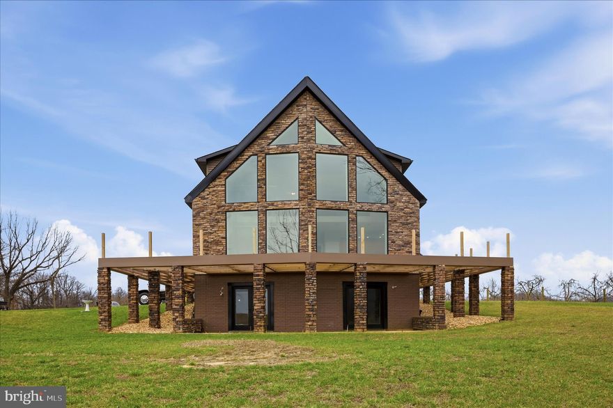 Panoramic Mountain Views Through Floor-to-Ceiling Windows.
Nearly completed custom home on 2 private acres just minutes from Gerrardstown, West Virginia, offering over 3,500 sq ft, designer architecture, and the opportunity to move into a finished home with room to expand. 
The main level will be completed prior to closing and features a spacious primary suite along with open-concept living areas ideal for both everyday living and entertaining. The upper level offers two additional bedrooms and a full bath, providing flexible space for family or guests.
Outdoor living is thoughtfully designed with a wraparound deck (will be completed prior to closing)  with a striking timber-frame inspired façade, as well as a covered side porch featuring stamped concrete, recessed lighting, and a ceiling fan—perfect for relaxing and enjoying the peaceful surroundings.

The walkout lower level already includes a full bath and offers exceptional potential for future expansion—whether for additional living space, recreation, or a private guest suite. Option to finish lower level with agreed upon price. Current list price includes 2 finished levels

Ideally positioned for those seeking a balance of privacy and accessibility, this property presents a compelling opportunity for buyers from surrounding metropolitan areas, including Northern Virginia and Washington, DC, who are looking for a spacious retreat with acreage, modern design, and the ability to add value over time.

A rare offering combining a near move-in-ready home, customization potential, and panoramic views—all within reach of major commuter routes.