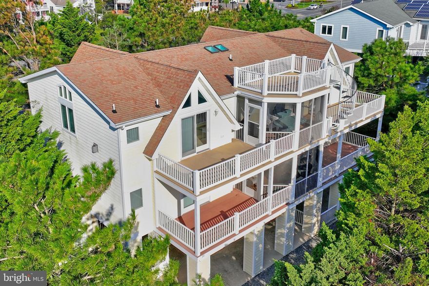 Stunning ocean block home offering a rare opportunity to experience coastal living at its finest. Situated in the picturesque private oceanfront community of Sandpiper Village, this home is located just 4 lots away from the lifeguarded and pristine sandy beaches of the Atlantic Ocean. This meticulously maintained home offers a thoughtfully constructed open inverted floor plan capturing panoramic ocean views. A large welcoming foyer leads up to an expansive custom spiral three level hardwood staircase. Take the elevator or the stairs to the spacious third floor with hardwood flooring throughout, vaulted ceilings, skylights and a window lined wall providing an abundance of natural light. The coastal-inspired decor and tasteful finishes adds to the overall charm and character of the home. The well-appointed kitchen is a chef's dream, complete with stainless steel appliances, custom cabinetry, wine and beverage cooler, retractable downdraft vent, abundant counter space, and a large island that serves as a convenient gathering spot for family and friends. Three separate levels of oceanside decking, including a rooftop sun deck and screened in area, totaling over 1,000 square feet, providing the ideal spaces for entertaining or relaxing. The property offers two master suites, providing a total of five bedrooms, each designed to provide comfort and relaxation. The master suite is a true retreat, featuring a private en-suite bathroom and two walk-in closets. The second floor offers four expansive bedrooms, three full bathrooms, private deck access and a wet bar and wine refrigerator. Wake up and hit the beach or unwind in the evening with a gentle ocean breeze flowing through the windows. Offered fully furnished, this home is ready to be enjoyed. The lower level offers a separate garage, fenced in area ideal for dogs and lots of storage space for your beach gear and watersports equipment. Two large outside showers and plenty of off-street parking for guests! Location is key, and this property offers the best of both worlds. Additional features include extra-thick walls to provide soundproofing, a Jacuzzi bathtub, built-in speakers, security system, architectural moldings, alarm system, 2 zone HVAC system, and the list goes on! Enjoy easy access to the beautiful beaches, where you can swim, sunbathe, or take long walks along the shore. Explore the vibrant town of Bethany Beach, filled with charming boutiques, delicious restaurants, and lively entertainment options. Whether you are seeking a year-round residence, a vacation home, or an investment property, this real estate gem has it all. Never rented but excellent rent potential; projected rental analysis available upon request. Schedule a showing today and prepare to fall in love with the coastal lifestyle that awaits you!