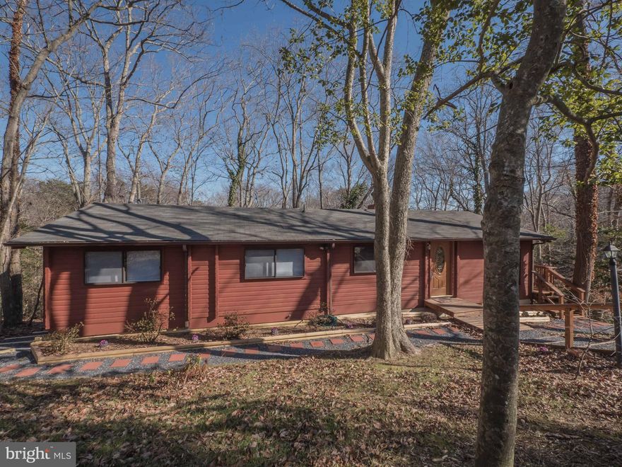 Newer Roof and Septic. Gorgeous log home built to last. Entrance opens to spacious kitchen and great room with arched doorways and wood beam ceilings. Cozy brick hearth fireplace with wood stove insert.  Newer french doors open to large private deck.  Owners suite has private deck. 2 Huge walk-in crawl spaces could be future basement.