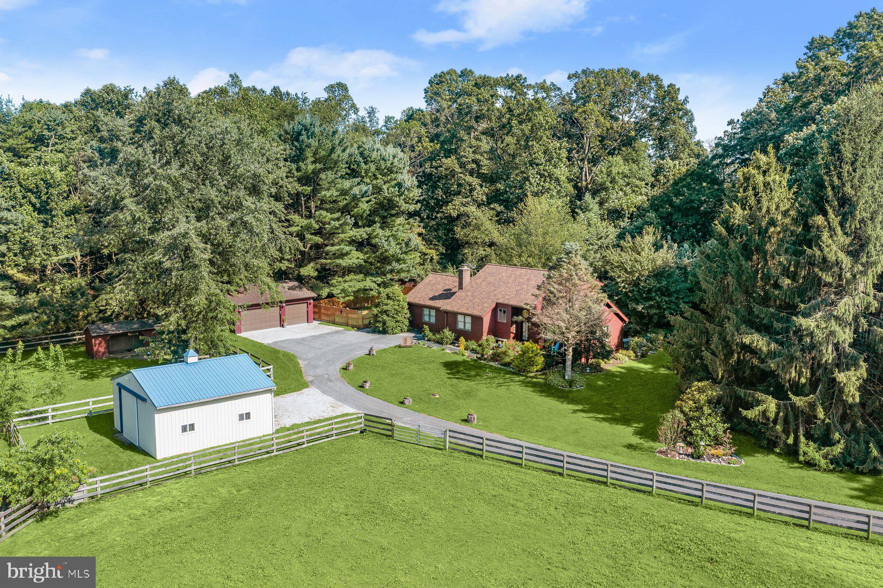 Welcome to 5129 Grave Run Road, a private sanctuary nestled down a secluded 1/4 mile lane on over 4 acres of wooded tranquility. Thoughtfully maintained and extensively improved over the last 20 years, this property is ideal for equestrians, contractors, homesteaders, gardeners, or anyone seeking peace and privacy.
The cedar contemporary home blends beautifully with its natural surroundings. Inside, an open floor plan is adorned in warm woods and inviting tones. The kitchen is designed for gathering, featuring an island and newer stainless steel appliances, and flows into a family room with soaring ceilings and a well-maintained wood-burning fireplace with custom metal doors. The main level includes a spacious primary bedroom, a sunroom with vaulted ceilings, a full bath, and a versatile office or formal dining room.
Upstairs are three additional bedrooms and a recently updated full bath. The finished basement currently includes a workshop and a separate media room but the possibilities are endless. Major updates to the home include a brand new roof, newer HVAC, and multiple ductless split systems for efficient climate control. The full list of improvements is too extensive to include here but is available in the MLS documents or upon request. The home offers almost 4,000 square feet of space, exceeding what is reflected in the tax records.
Step outside to explore multiple decks and winding paths through hundreds of unique mature plantings. A nearly-new potter’s shed awaits your green thumb, and a large 30' x 60' fenced area could serve as a garden or pet enclosure. Across the driveway is a car enthusiast’s or contractor’s dream: a 24' x 32' detached three-car garage (built in 2021) with its own 100-amp panel—perfect for workshops or hobbyists.
Horse lovers who want to avoid the cost of boarding will be thrilled by the well-equipped 24' x 24' stable, offering two 12' x 12' stalls with bluestone substrate base and stall mats, level fenced pastures, a run-in shed, and a Nelson self-waterer—the entire set up all visible from the front porch of your new home.
Every aspect of this property—from the home and garage to the stable and gardens—has been meticulously maintained. Just a short drive to parks, trails, lakes, and Prettyboy Reservoir, this one-of-a-kind property offers privacy, beauty, and functionality in equal measure.