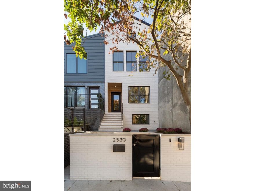 Welcome to 2530 Pine Street in Fitler Square -- an architect designed dream home with 3 bedrooms, 3 bathrooms and PARKING.  Set back from the street, you'll notice the striking 3 story facade made of white brick with black Pella windows and a custom front door with cedar surround. Enter into the front gate, and up the stairs to your private patio with Pennsylvania blue flagstone pavers, garden beds, and city views.  The open living room/dining room has high ceilings, recessed LED lighting, wood burning fireplace and an abundance of natural light from oversized custom windows on the south & north ends of the home. The eat-in kitchen is off of the expansive living/dining room and features contemporary white cabinetry with quartz countertops, tile backsplash and fitted with a commercial style Wolf range and Sub-Zero refrigerator and dishwasher.  The upper level of this property houses 2 bedrooms and 2 bathrooms.  The guest bedroom is spacious with south facing windows and adjacent to a hall bathroom with duel sink vanity, tub with tile surround and geometric floor tiles.  The master suite is stunning with a 15' cathedral ceiling, oversized windows with amazing skyline views, multiple closets -- including a large walk-in, plus an en-suite bathroom with a duel sink vanity, shower with sliding glass doors and marble tile surround.  The ground level features the 3rd bedroom with a walk-in closet, a full hall bathroom with penny tile, single vanity and stall shower, plus an additional open room for use as an office, den, playroom or home gym.  This room gets great light from the rear picture window and has direct access to the deeded parking space with gated driveway and rear yard. The laundry area, with full sized LG washer, dryer plus laundry sink, is also located on the ground level.  Other highlights of this property include custom Pella windows throughout, 2 zones of HVAC, Nest thermostat, wide plank French oak wood flooring, Ring security doorbell, plus completely wired for phone, internet & cable. Approved for 10 year tax abatement!  Incredible Fitler Square location with direct access to community tennis courts, dog park, Schuylkill River jogging/biking/walking trail, Fitler Square park, neighborhood coffee shops, retail, dining & more! Perfect commute to UPenn, CHOP & Drexel and easy access to 30th Street Station & I-76.