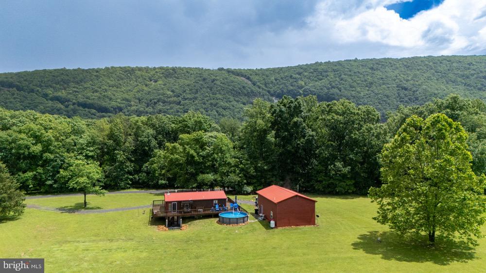With 2 acres of country views, and easy access to the river, your private oasis in the mountains awaits! This hand built cabin boasts, 2 beds, 3 baths, a finished basement with HEATED FLOORS, and an oversized garage with an extra room and bathroom. The bonus feature is your own personal elevator/chairlift in the main house and garage for you to perfectly age in place! And we can't forget the heated pool and wrap around deck perfect for entertaining. You've got to see this retreat in person. Over the (Cacapon) river and through the woods, to your new house you go!
