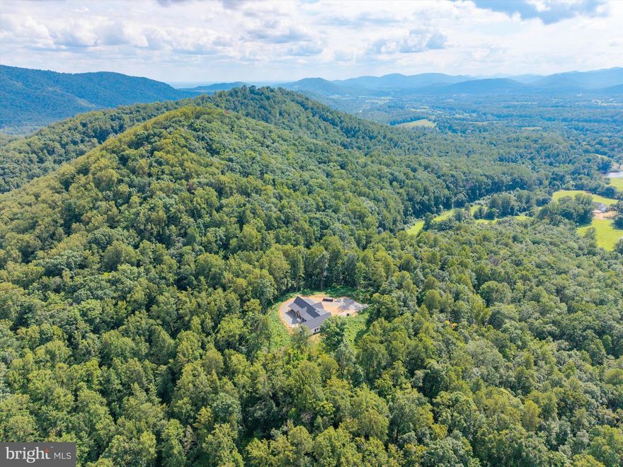 COMPLETION SET FOR DECEMBER 2025! ONCE IN A LIFETIME LUXURY NEW CONSTRUCTION IN THE PRESTIGIOUS BLANDEMAR ESTATES SUBDIVISION! This luxury gem is nestled on 24 private acres with panoramic views of mature hardwoods and the breathtaking Blue Ridge Mountains. This exceptional 4,806 SF estate with a FLAT HOMESITE offers refined one-level living with 5 spacious bedrooms and 4 beautifully appointed bathrooms. A small, serene creek meanders through the edge of the property, enhancing the peaceful, secluded setting. Inside, the custom design and finishes are second to none — from the gourmet kitchen with panelized appliances, floor-to-ceiling cabinetry, and a large walk-in pantry, to the vaulted and tray ceilings, custom-stained plank ceilings, and expansive open-concept living spaces (more....)

Entertain in style with a dedicated wine area featuring 300-bottle built-in wine storage coolers, a wet bar with sink and kegerator, and a cozy lounge with fireplace. The luxurious master suite wing and separate full guest suite offer privacy and comfort, while a fitness room, sauna/hot tub connection, and outdoor shower elevate the lifestyle. Step outside to expansive covered porches with fireplaces  perfect for year-round enjoyment of the mountain views. Additional features include an EV charger and meticulous attention to detail throughout. The bathrooms are no less of a slice of paradise- full tiled showers with a lavish master shower featuring a rainshower and freestanding soaking tub. This is a truly rare offering  where modern luxury meets natural beauty in the heart of the Blue Ridge.