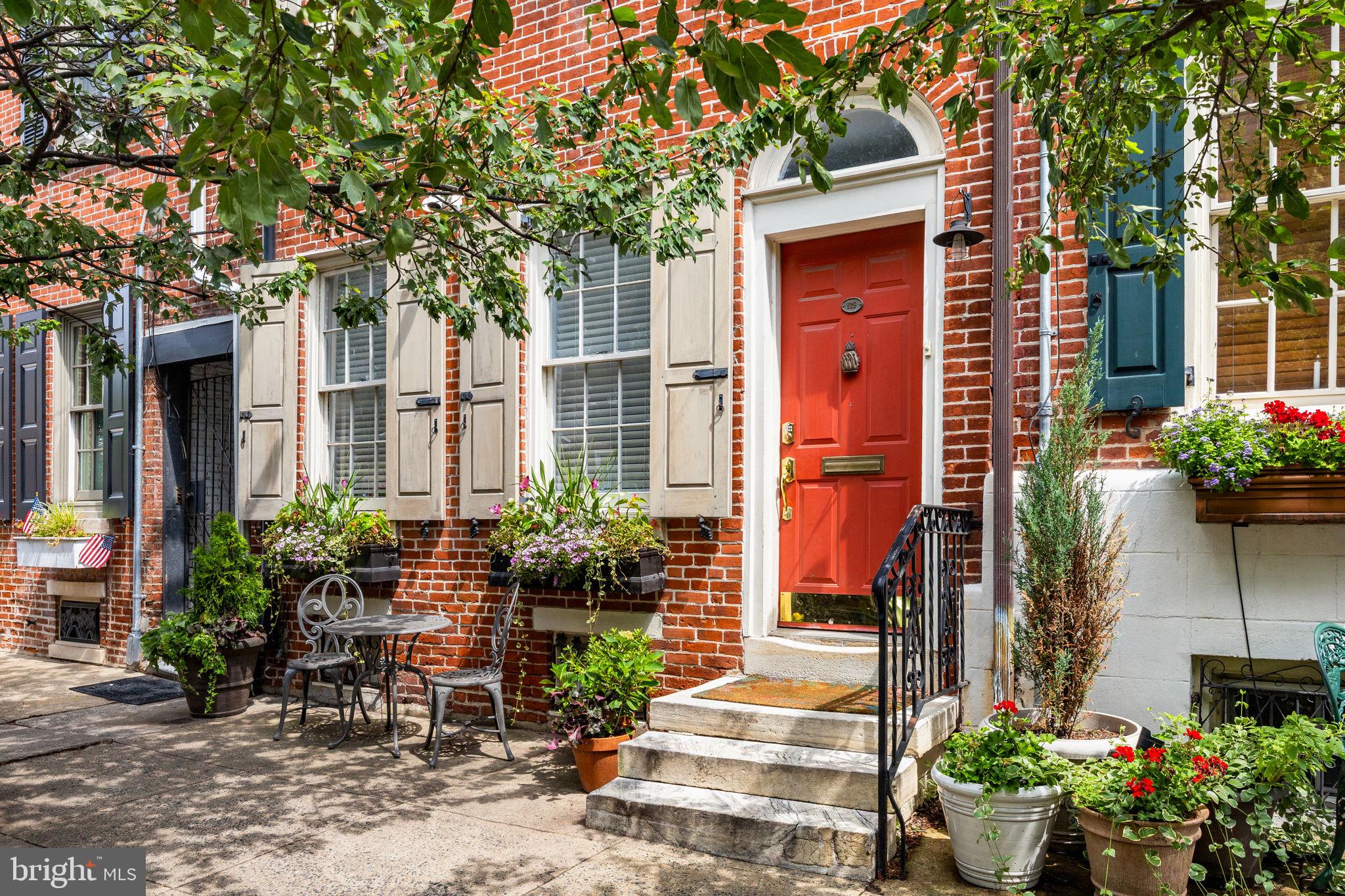 Welcome to 129 Bainbridge, a distinctive residence tucked along a picturesque, tree-lined street in the heart of Queen Village.
This rare offering combines a sophisticated four-story townhome with a charming trinity-style annex, accessible through a private gated entrance. Together, they present an exceptional opportunity for multi-generational living, an au pair or guest suite, or an income-producing residence.
The main townhome unfolds with an elegant sense of proportion and detail. The formal living room greets you with a fireplace mantle and bespoke built-ins —a refined yet inviting setting. This level also features a full bedroom and bath, plus the washer & dryer, ideal for guests or a home office.
The second floor is designed for gathering: an open, contemporary kitchen with abundant cabinetry overlooks a gracious family room anchored by another fireplace and custom shelving. A formal dining room and powder room enhance the home’s sense of ease and flow, making entertaining effortless.
On the third floor, a private bedroom suite with en-suite bath is paired with a den or office space, offering access to a serene outdoor deck. A wet bar is also on this level for easy access when enjoying al-fresco drinks. The top floor is devoted to the primary suite, crowned by vaulted ceilings. Here, a walk-in closet and spa-inspired bath with seamless glass shower, free-standing soaking tub, and double vanity create a true sanctuary.
Additional features include a full, unfinished basement with ample storage space.
Beyond the primary residence, a landscaped courtyard leads to the adjoining Trinity, which features one bedroom with 1.5 bathrooms, plus an unfinished basement with laundry facilities. Steeped in historic charm yet flexible in function, this separate dwelling extends the home’s possibilities—whether as a rental, a private retreat for guests, or a quiet studio tucked away from the city’s energy.
129 Bainbridge is a rare blend of architectural character, thoughtful design, and urban versatility—all in one of Philadelphia’s most beloved neighborhoods. Located within the Meredith Elementary School catchment.