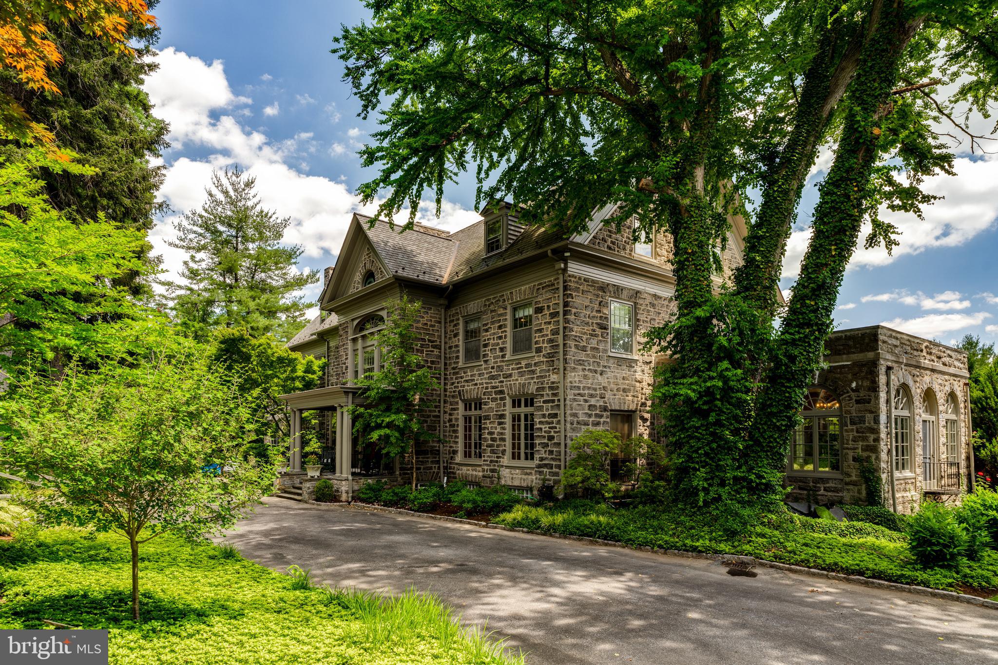 Immerse yourself in the storied grandeur of 1221 Lafayette Rd, an architectural jewel spanning 9,388 square feet, originally constructed in 1895. This remarkable residence exemplifies the pinnacle of historic craftsmanship, with every detail meticulously preserved to honor its legacy. Rich woodwork, ornate plaster motifs, and opulent marble and wood fireplace surrounds are woven throughout, creating an atmosphere of refined elegance that echoes through the centuries.
Set within a tranquil suburban enclave, the estate offers seamless access to Center City, the Philadelphia Airport, and the vibrant Main Line corridor, home to charming boutiques, fine dining, and cultural attractions. French doors punctuate the home’s façade, gracefully leading to a sprawling stone terrace. From here, the vista unfolds—a glittering swimming pool framed by manicured gardens, with mature centennial and blossoming trees dotting the landscape, enhancing the estate’s secluded, park-like allure. Privacy is paramount, with fencing that secures the grounds while blending harmoniously with the natural surroundings.
Upon entry, the grand center hall makes a striking first impression, featuring limestone, oak, parquet, and marble floors that carry throughout the home. The architectural flow transitions effortlessly between formal entertaining spaces and intimate retreats, offering both grandeur and comfort.
The formal living room stands as a testament to the home’s historic pedigree, showcasing original paneling sourced from an 18th-century German castle, crowned with intricate moldings. A stately wood-burning fireplace anchors the space, surrounded by built-ins and flanked by twin sets of French doors opening to the terrace. Adjacent is the sunlit game room, where arched windows on three sides bathe the space in natural light, making it an ideal setting for hosting poker nights or musical soirées.
The dining room exudes timeless sophistication, with wood floors underfoot, a handsome fireplace, and a ceiling adorned with delicate plaster flourishes. A richly paneled study offers a sanctuary for contemplation, with built-ins, a hidden passage to the kitchen, and a wood-burning fireplace adding to its charm. Just beyond, the family room beckons with its cozy ambiance, providing a restful space for relaxation.
At the heart of the home lies the kitchen, thoughtfully updated with modern amenities. A generous island with a prep sink anchors the space, accompanied by a six-burner Viking gas cooktop, dual wall ovens, a double Electrolux refrigerator, and a breakfast nook. French doors extend the kitchen into the outdoor living space, offering a harmonious blend of indoor-outdoor dining.
Ascending to the second floor, the primary suite reveals a serene retreat with wood flooring, French doors leading to a private balcony, and a walk-in closet. A sitting area connects to the sleeping quarters via a Jack-and-Jill bathroom, while the ensuite bath boasts granite-topped double vanities, a soaking tub, and a stone-tiled shower with a built-in bench, all illuminated by abundant natural light. The remaining second-floor bedrooms are equally charming, complemented by an expanded laundry room equipped with a Samsung washer and dryer, dual sinks, and balcony access.
On the third floor, a versatile landing area—spotlit and framed by warm wood floors—leads to Bedroom 5, a former dance studio complete with mirrored walls and ballet bars, offering endless possibilities as a fitness studio or creative space.
Outside, the estate continues to impress. The stone terrace, which stretches along the length of the house, serves as the perfect venue for grand outdoor gatherings. Adjacent to the kitchen, a more intimate patio with fenced flooring provides a serene spot for morning coffee or al fresco dinners. The pool, complete with a spa, is accessed via a flight of elegant stone steps, creating a picturesque focal point within the meticulously landscaped grounds.
1221 Lafaye